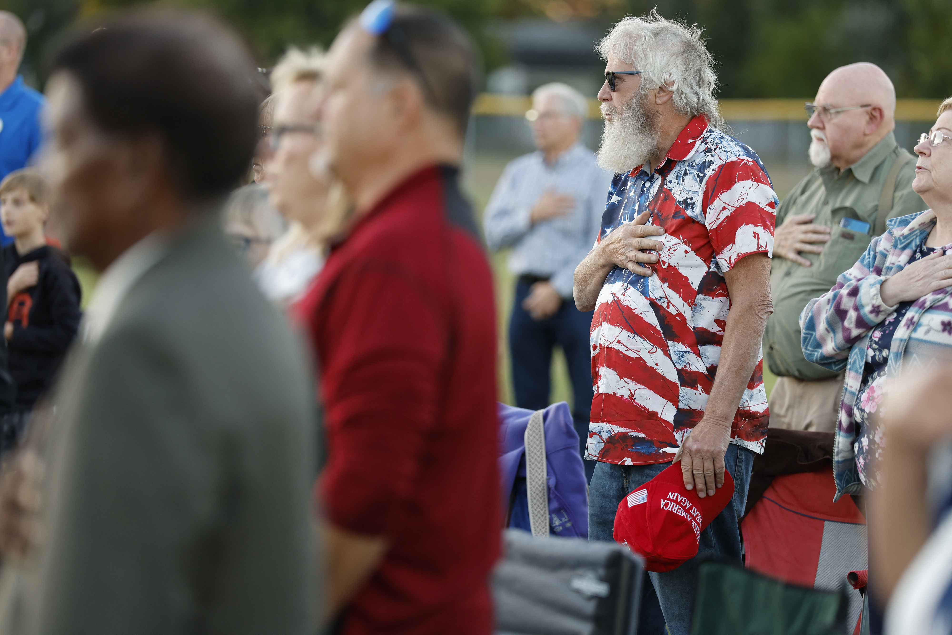 People at a prayer vigil led by Pastor Fr. Georges Bidzogo outside Holy Redeemer Church in Burton, Michigan, on September 28, 2025. | Source: Getty Images