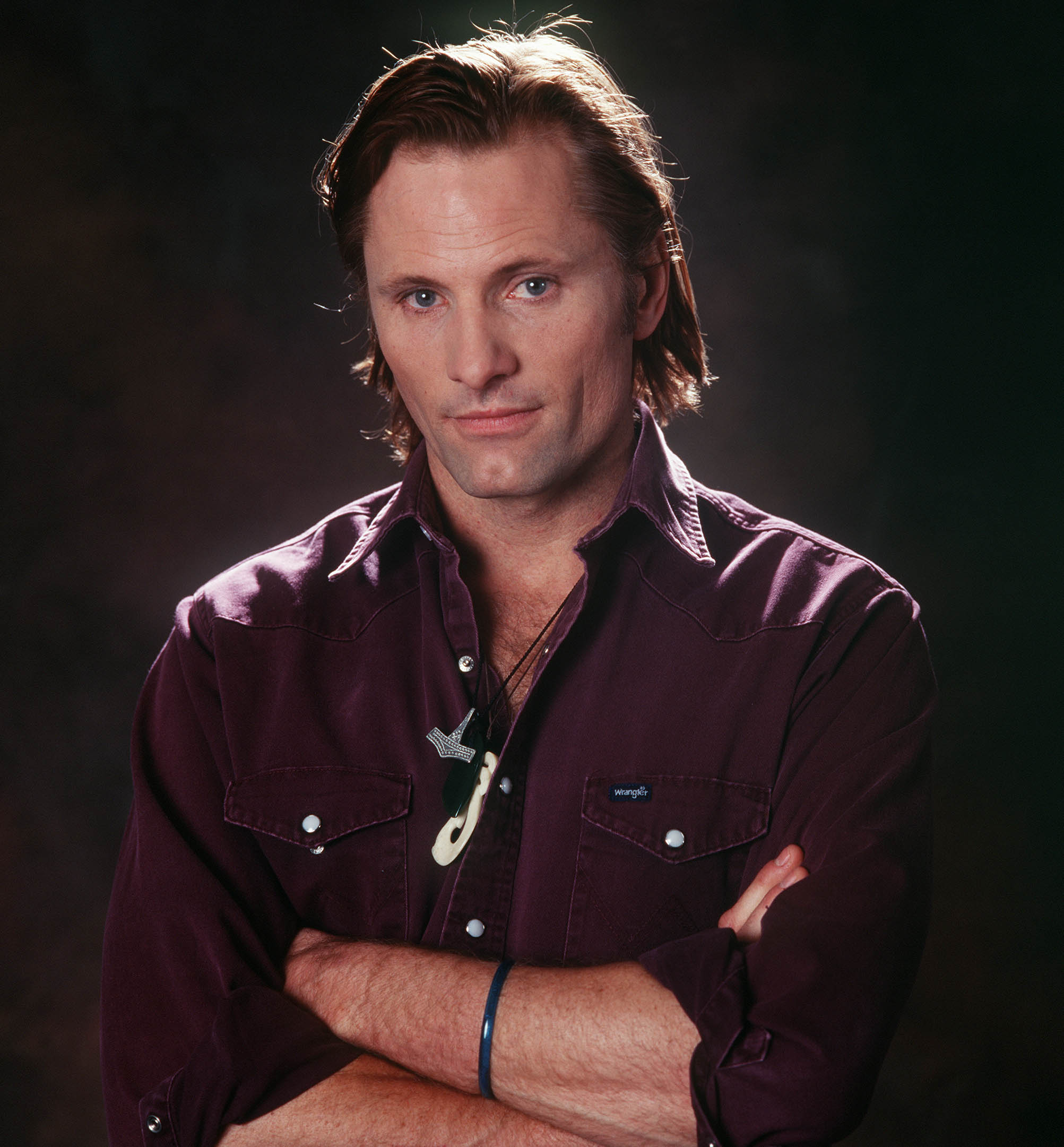 Viggo Mortensen posed for a portrait at the Waldorf Astoria Hotel in New York on December 5, 2001, the same year audiences first saw him as Aragorn in "The Lord of the Rings." Wearing a dark burgundy shirt with his arms crossed, the actor had stepped into the pivotal role shortly before filming began, replacing the original performer after months of rehearsals had already taken place in New Zealand.