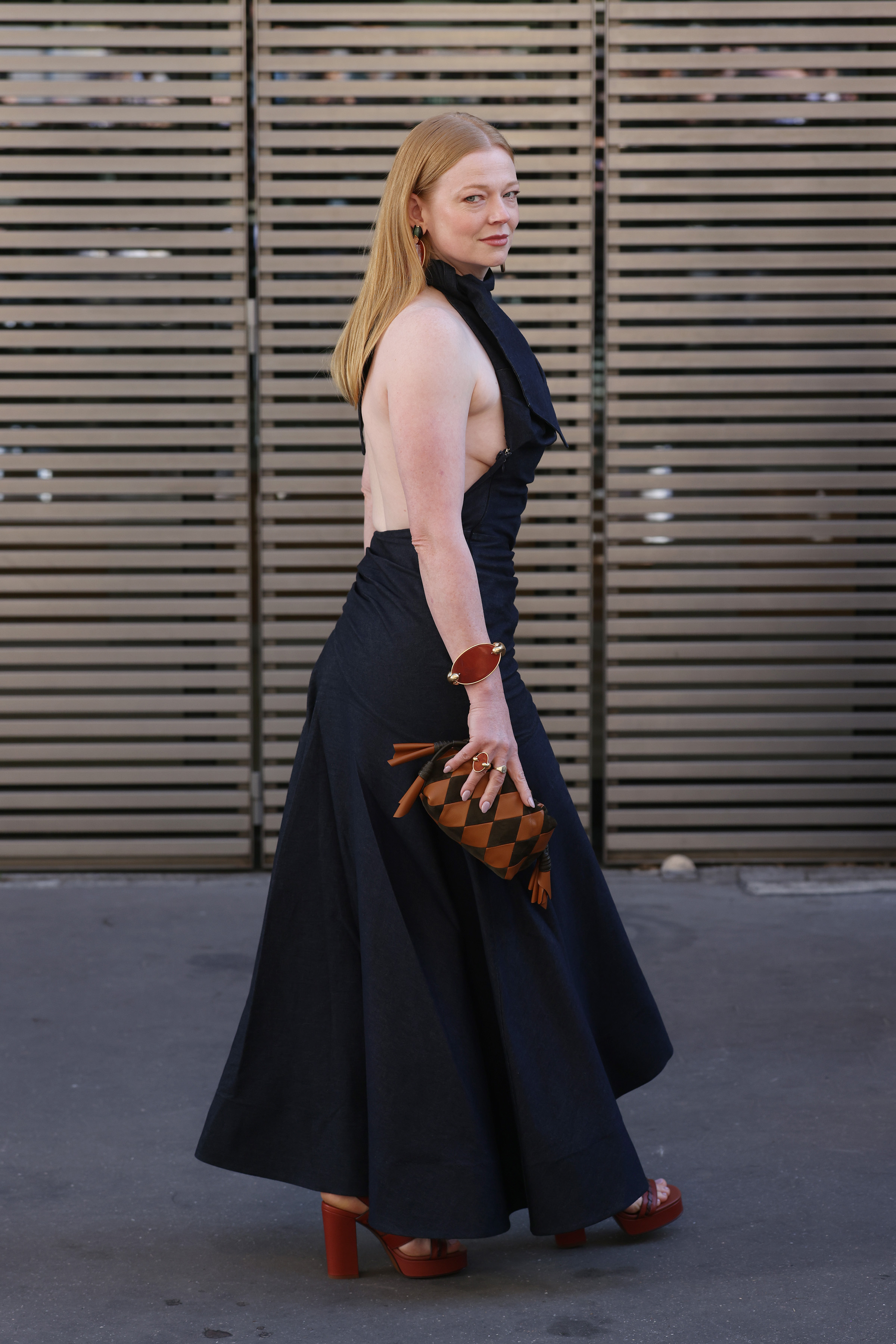 An open back and sweeping skirt give Sarah Snook's black dress its dramatic shape. Brown accessories add a warmer note as she arrives at Zimmermann. | Source: Getty Images