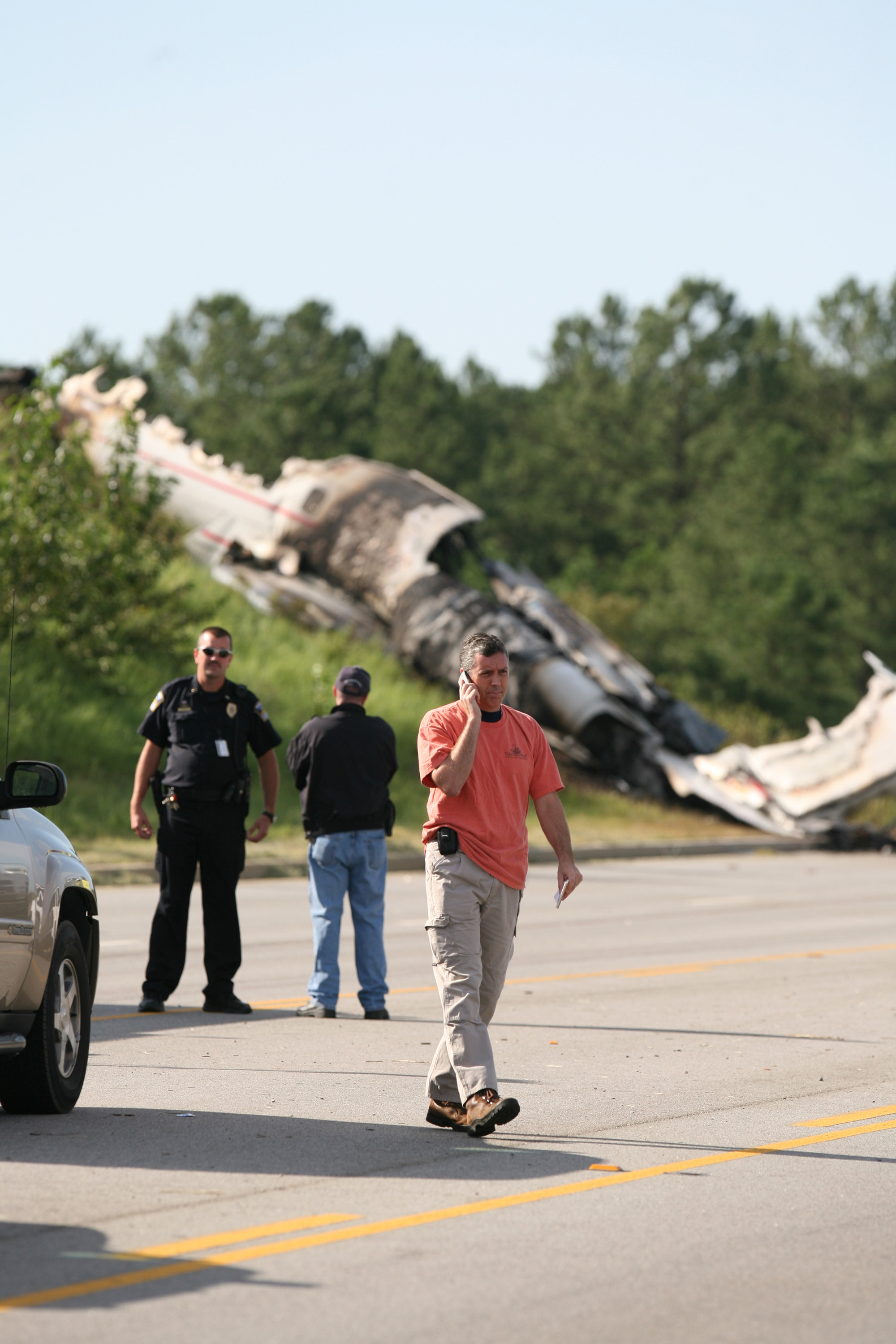 An official walked near the scene as the burned remains of the private jet sat on an embankment outside Columbia Metropolitan Airport in West Columbia, South Carolina, on September 20, 2008. | Source: Getty Images