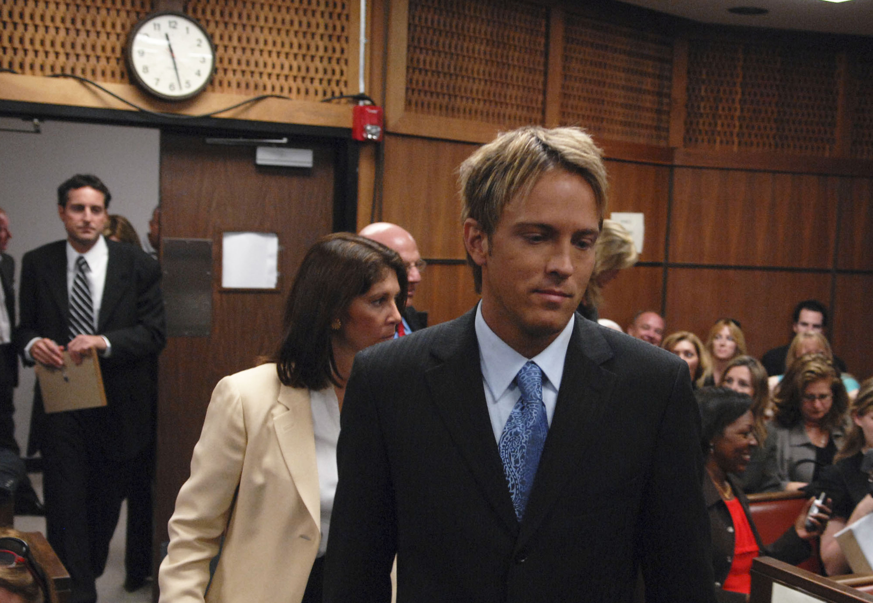Navigating the intense media spotlight inside a Broward County Circuit Court courtroom on February 20, 2007, 34-year-old Larry Birkhead appeared alongside attorney Deborah Opri for hearings to determine the custody of Anna Nicole Smith's remains. Dressed in a dark tailored suit paired with a light blue shirt and a patterned blue tie, his solemn expression captured the heavy gravity and high-stakes legal battle for his daughter.