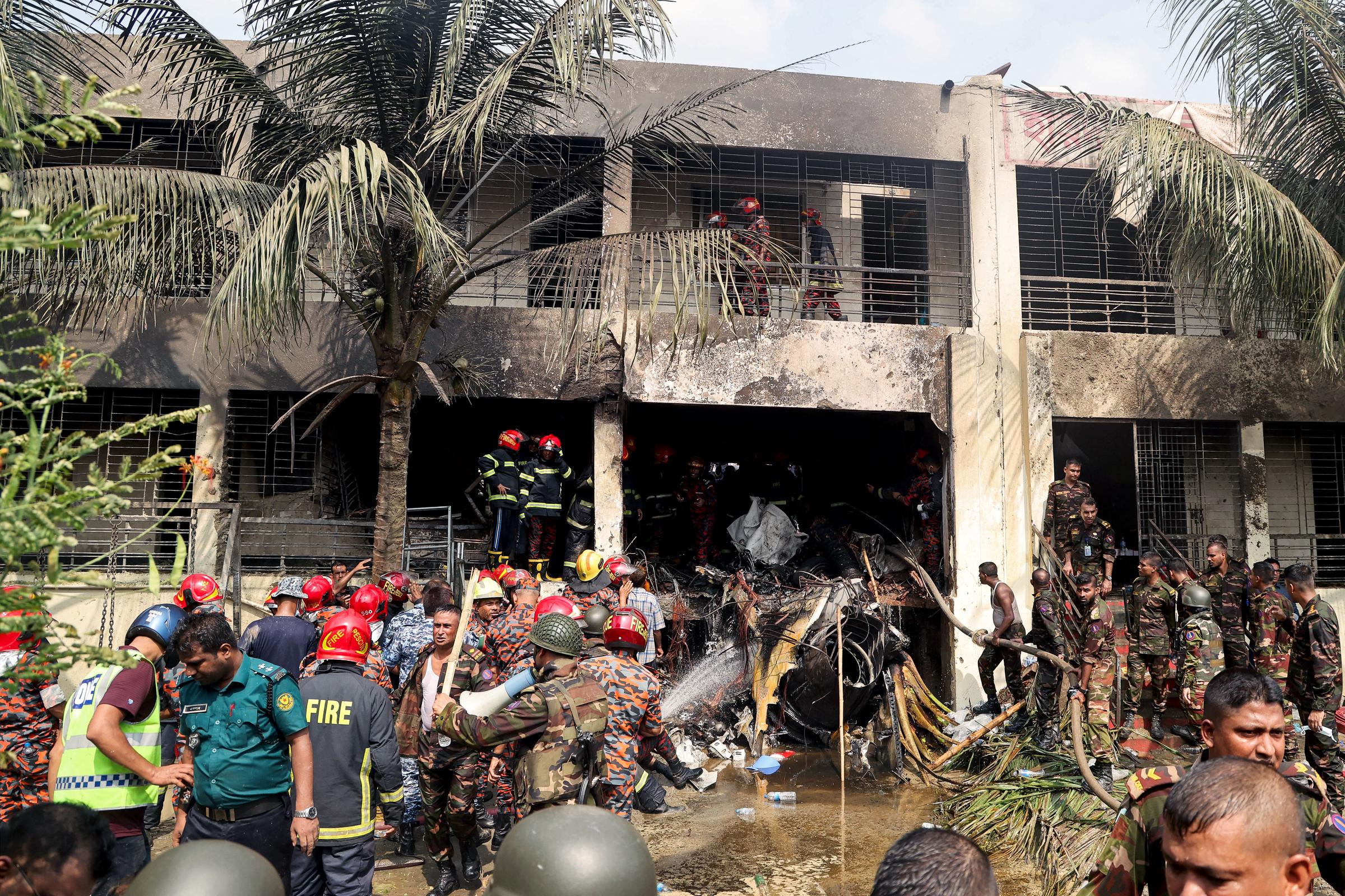 Bangladesh's fire service and security personnel conduct a search and rescue operation after an Air Force training jet crashed into Milestone School and College in Dhaka on July 21, 2025 | Source: Getty Images