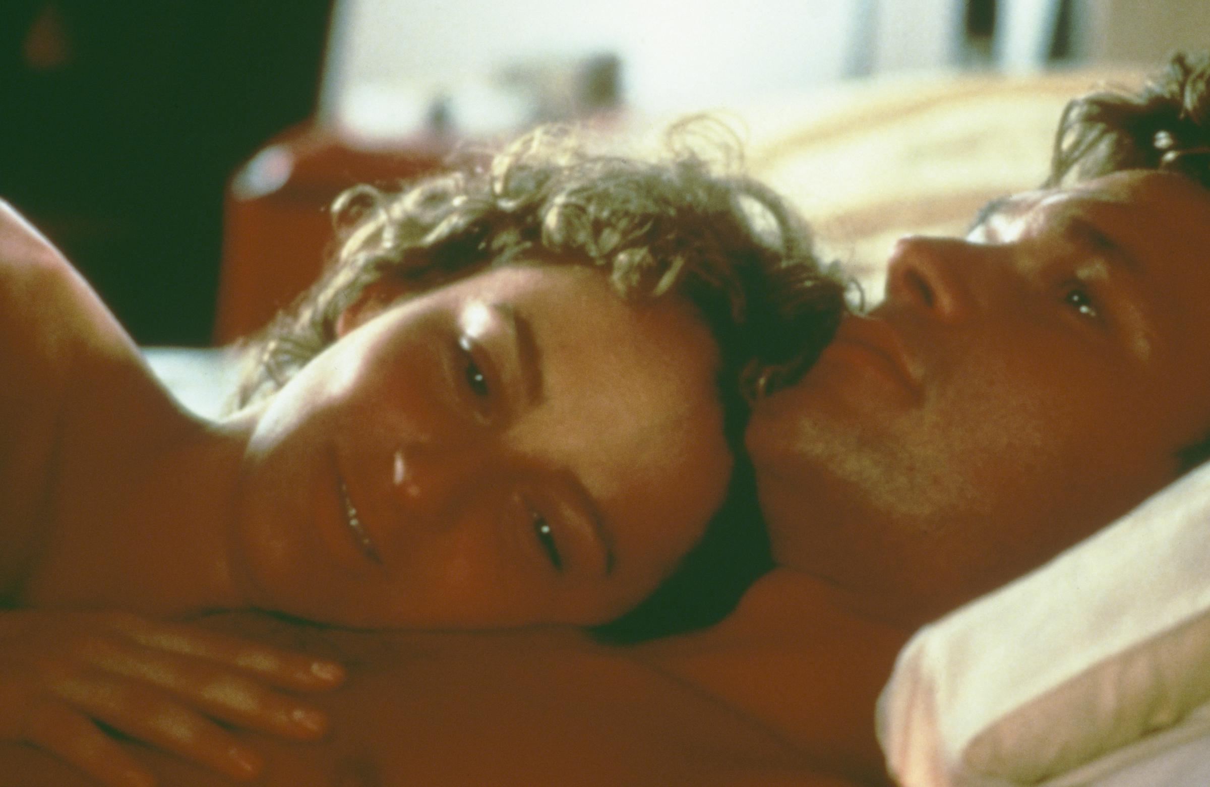 Baby smiles as she lays her head against Johnny's chest after the two were intimate. | Source: Getty Images