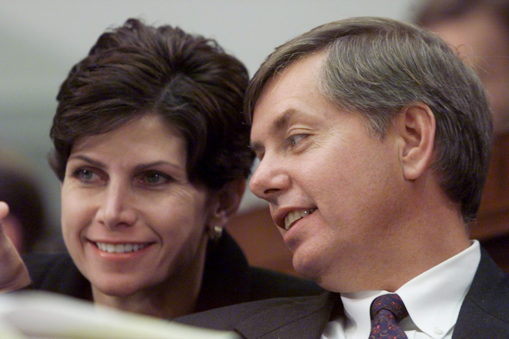 Lindsey Graham confers with Rep. Mary Bono during a House Judiciary Committee hearing, appearing deeply engaged as lawmakers weigh one of the era's most closely watched political proceedings. The candid moment highlights his early role in high-stakes congressional debates. | Source: Getty Images