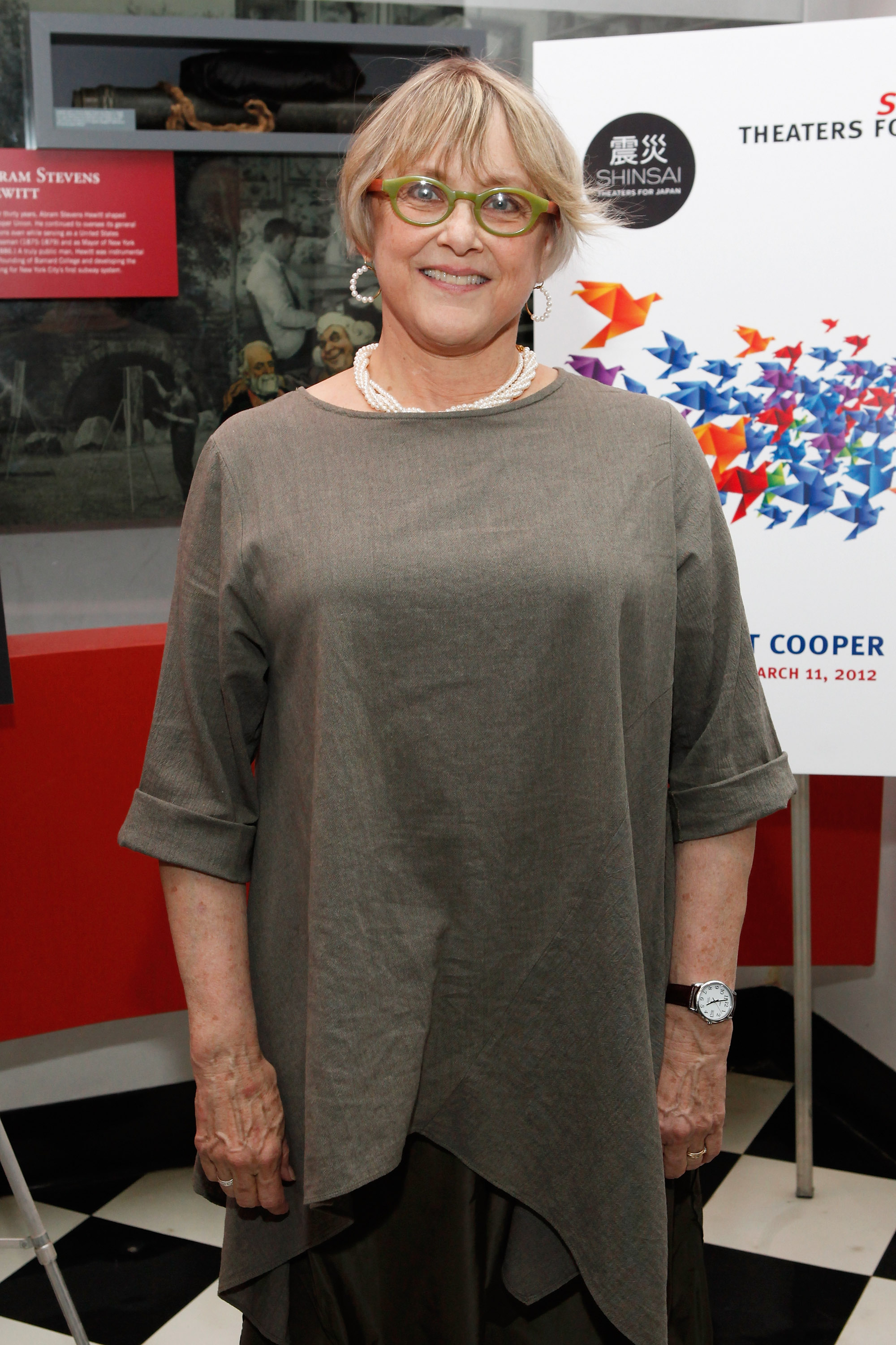 Mary Beth Hurt attends the "Shinsai: Theaters for Japan" benefit at Cooper Union in 2012, wearing a loose gray tunic, layered pearls, and green-rimmed glasses. Her calm smile and understated look suited the charitable New York event.