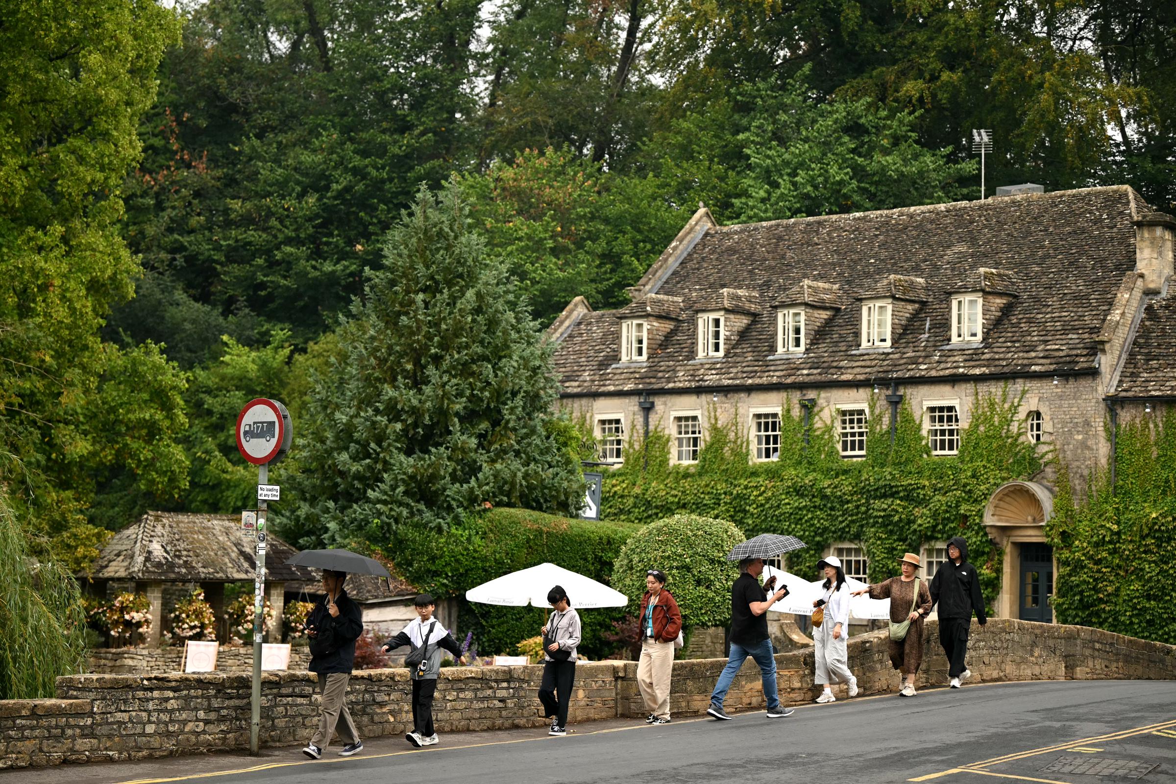 People walk through Bibury in the Cotswolds on August 27, 2026. Harry and Meghan were said to favor a secure countryside setting with access to outdoor activities and a strong sense of community for Archie and Lilibet. | Source: Getty Images