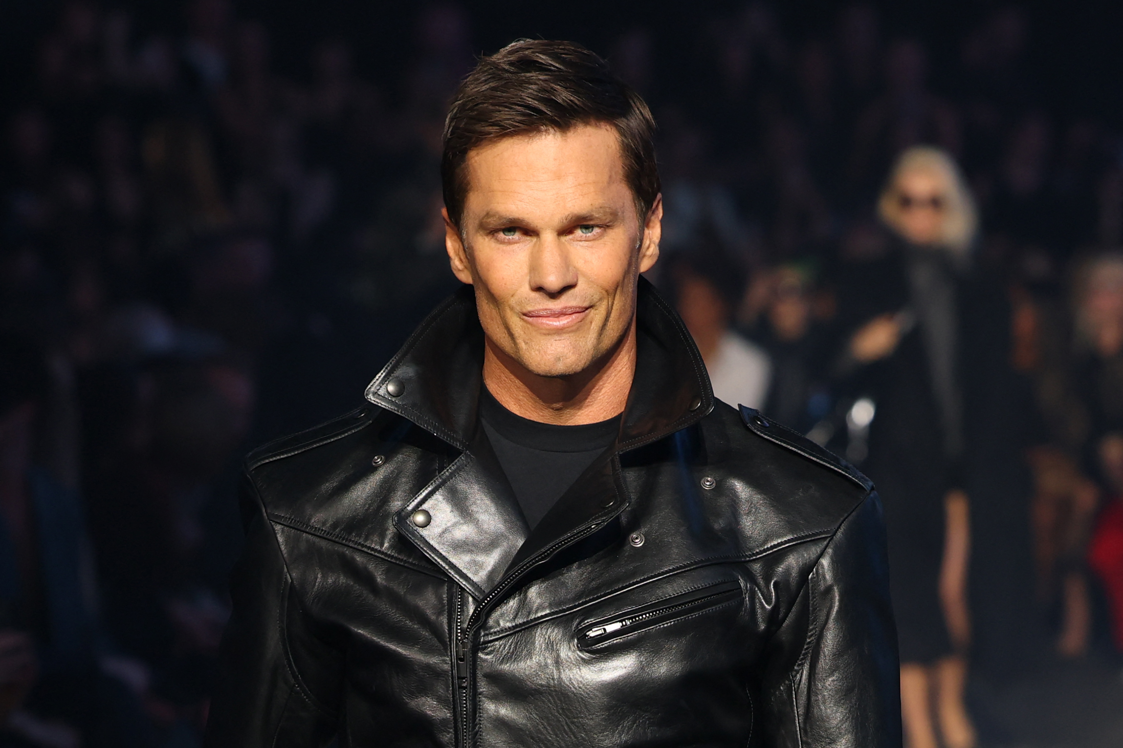 Tom Brady walked the runway during the Gucci Cruise 2027 fashion show in New York's Times Square on May 16, 2026. The appearance showcased the former NFL star's polished look and sharply defined facial features, which have fueled years of speculation about whether cosmetic procedures contributed to his youthful appearance.