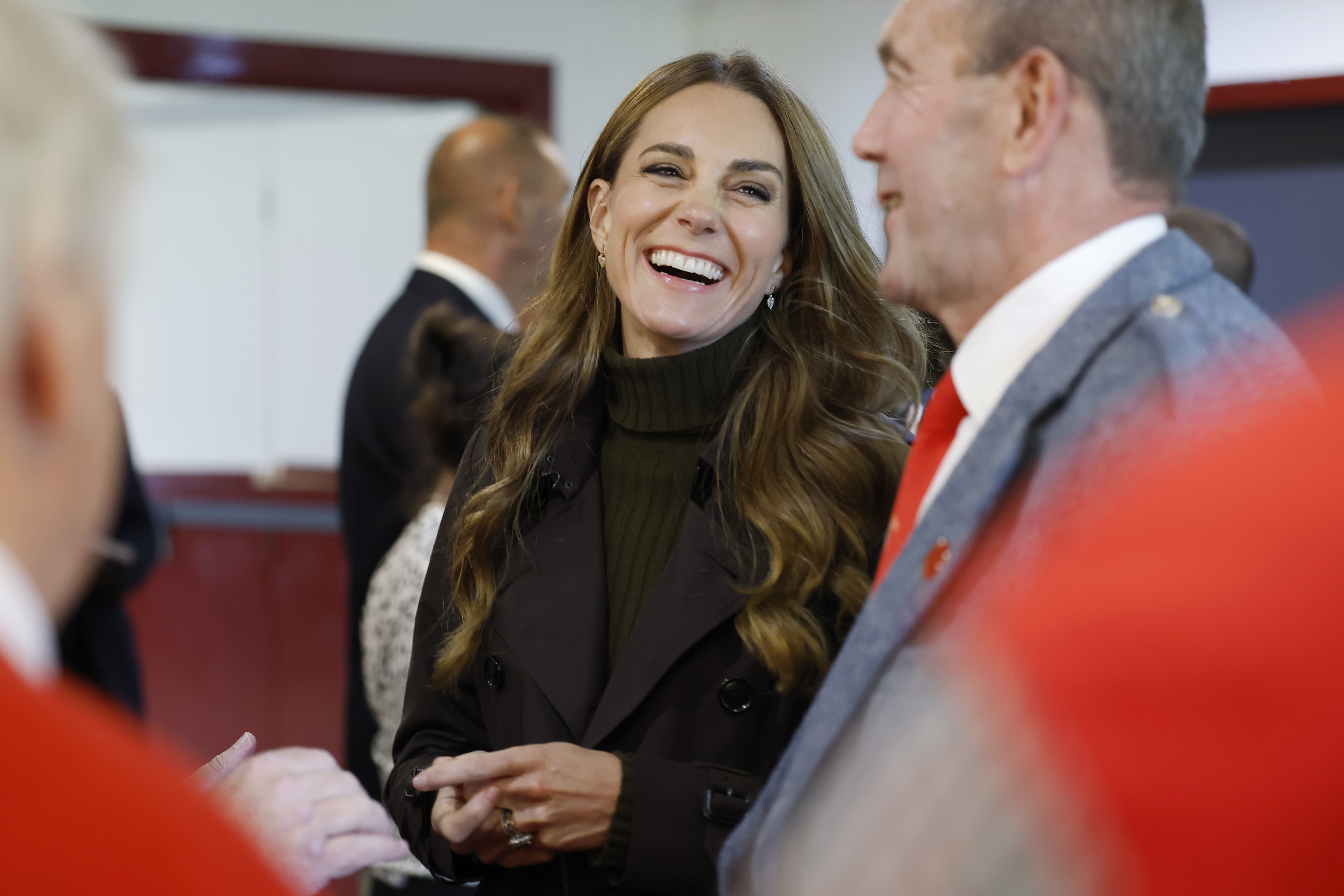 Catherine, Princess of Wales, shares a big laugh with attendees during her visit to Bute Shinty Club, appearing relaxed as she chats with those gathered around her. | Source: Getty Images