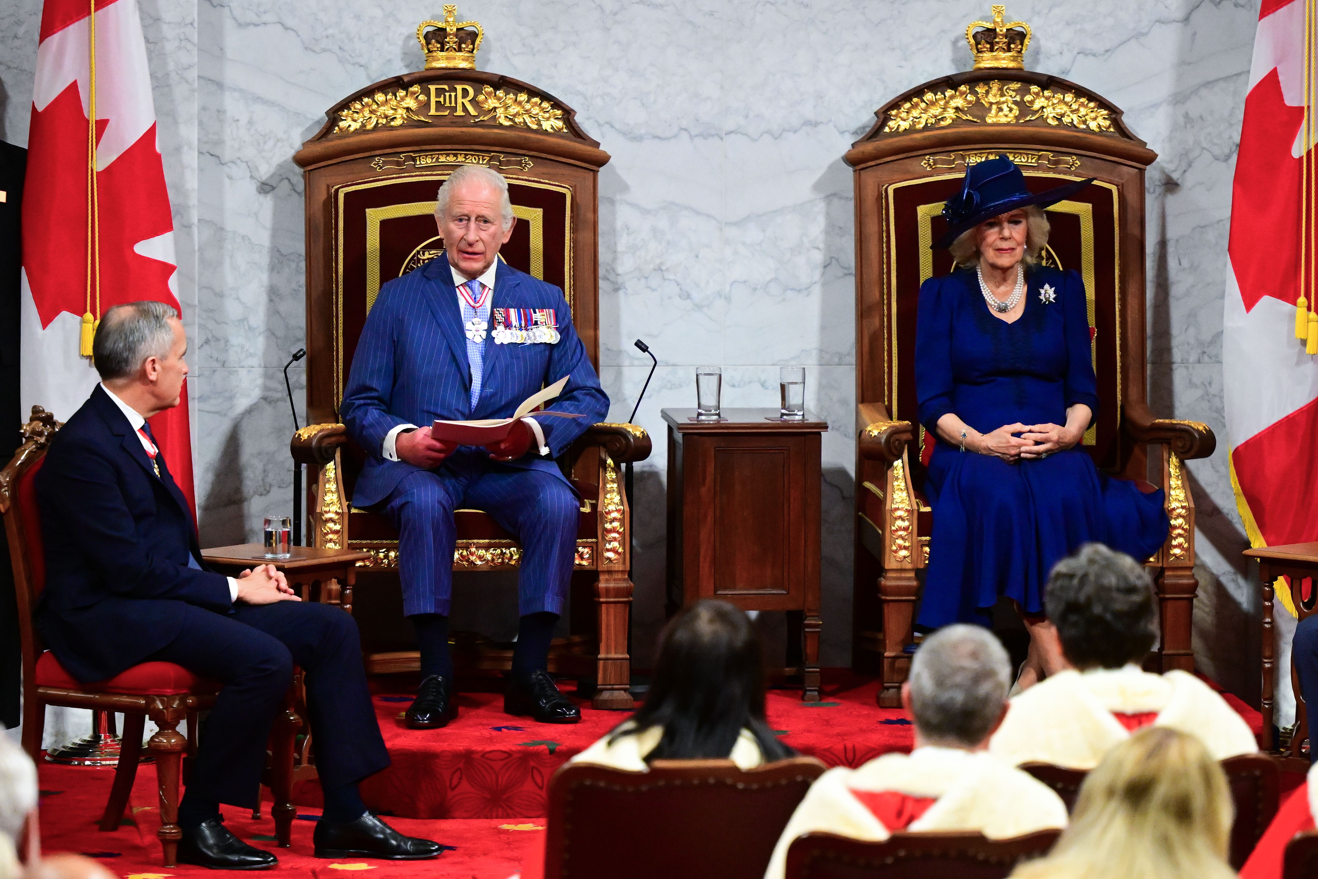 King Charles III, seated beside Queen Camilla, delivers a speech from the Throne to open the first session of the 45th Parliament of Canada, as Prime Minister Mark Carney looks on in the Senate.