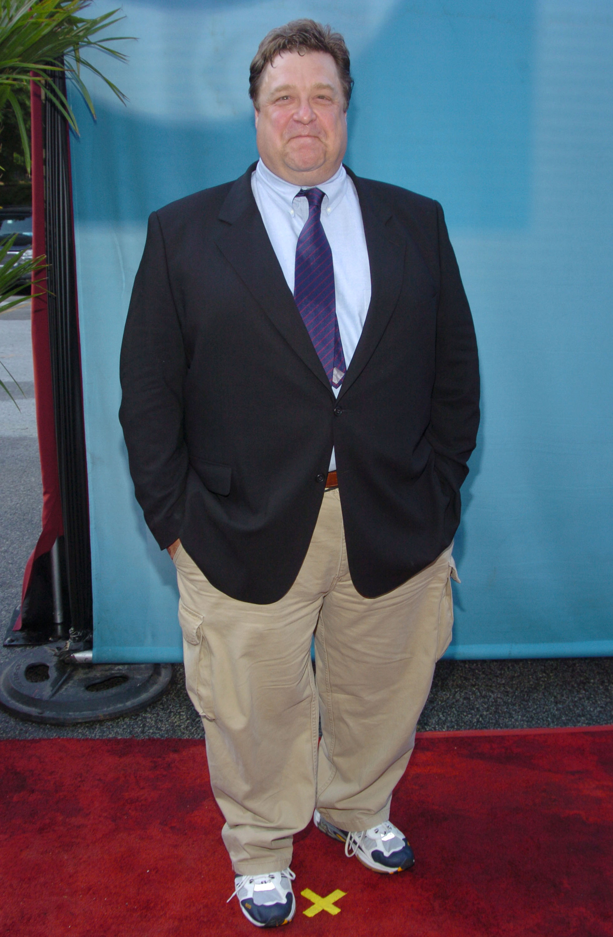 During CBS Primetime 2004-2005 UpFront - Party at Tavern on the Green in New York City, Goodman posed for photos in a creamish-brown trousers with brown belt worn on a light blue shirt. He paired the shirt with a striped tie in dark blue color before finishing off the outfit with a black suit jacket.