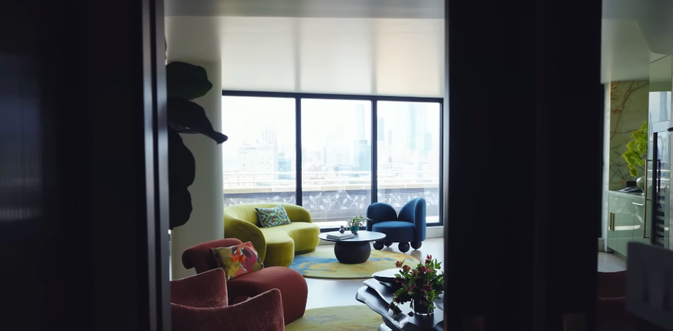 Even glimpsed through a doorway, the home's unusual palette immediately pulls the eye inward. The combination of citrus green, navy and panoramic glass makes this corner one of its most memorable. | Source: YouTube/Architectural Digest