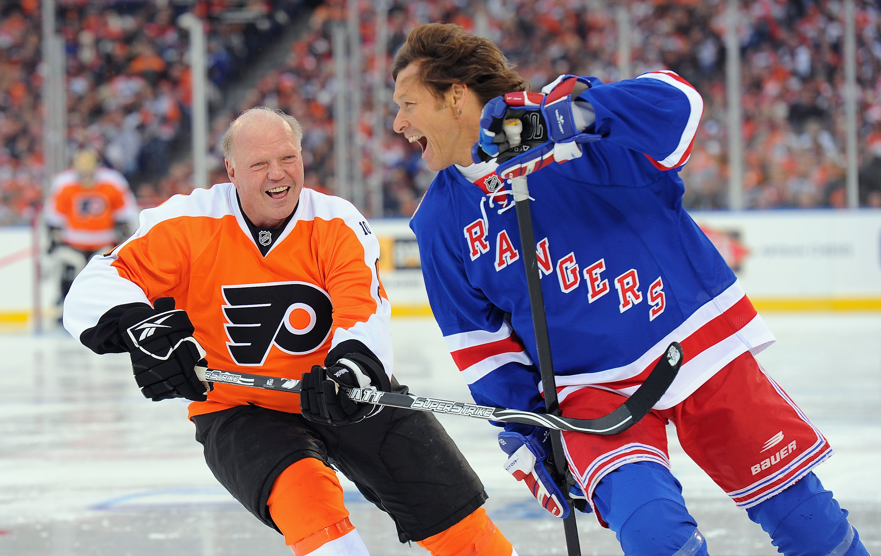 Duguay shares a laugh with former Philadelphia Flyers player Bob Kelly during an alumni game in Philadelphia on December 31, 2011. The event brought retired players back onto the ice ahead of the 2012 NHL Winter Classic. | Source: Getty Images