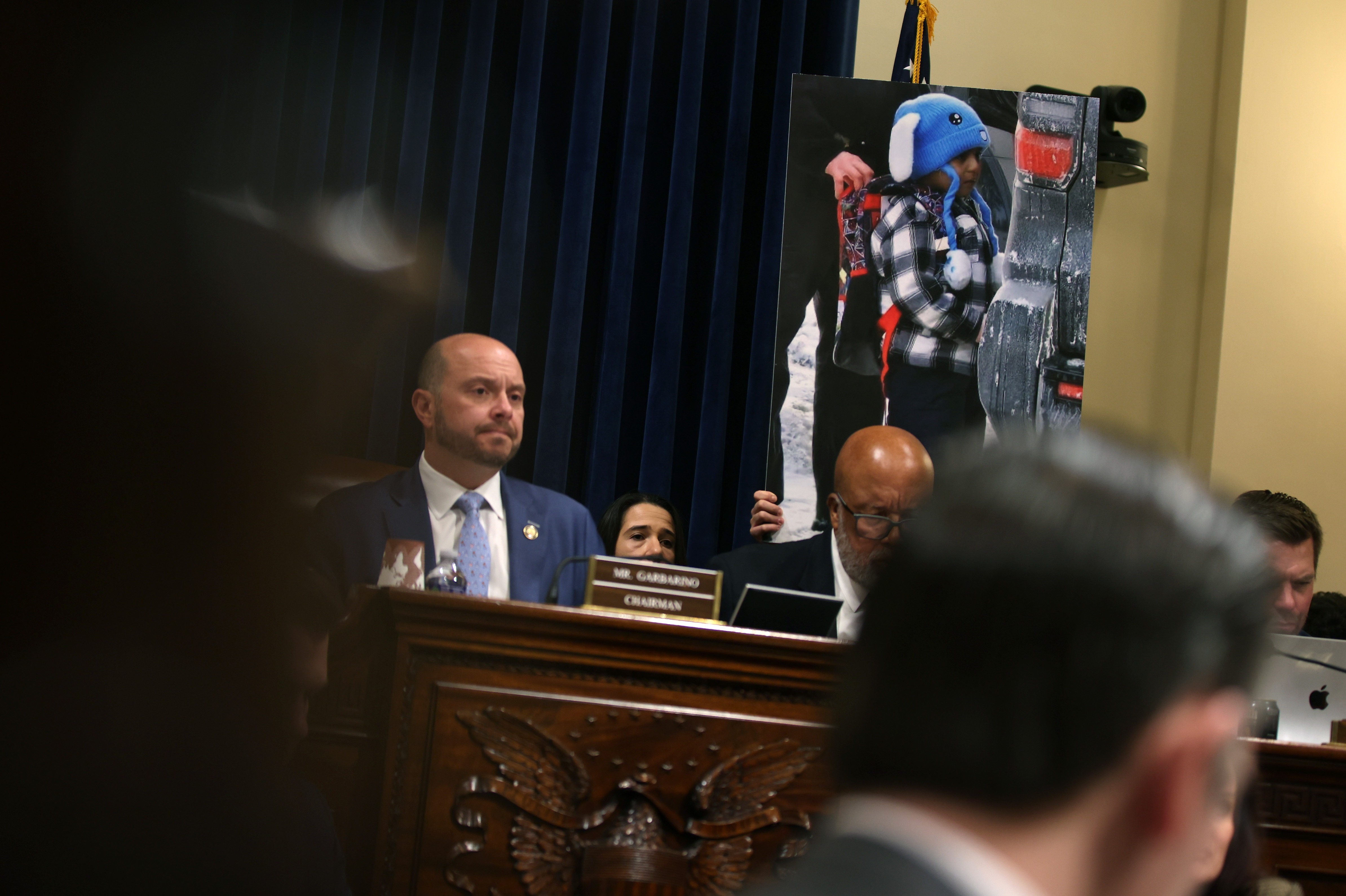 Government officials testify during a February 10, 2026 hearing, as an image of Liam Conejo Ramos is displayed | Source: Getty Images