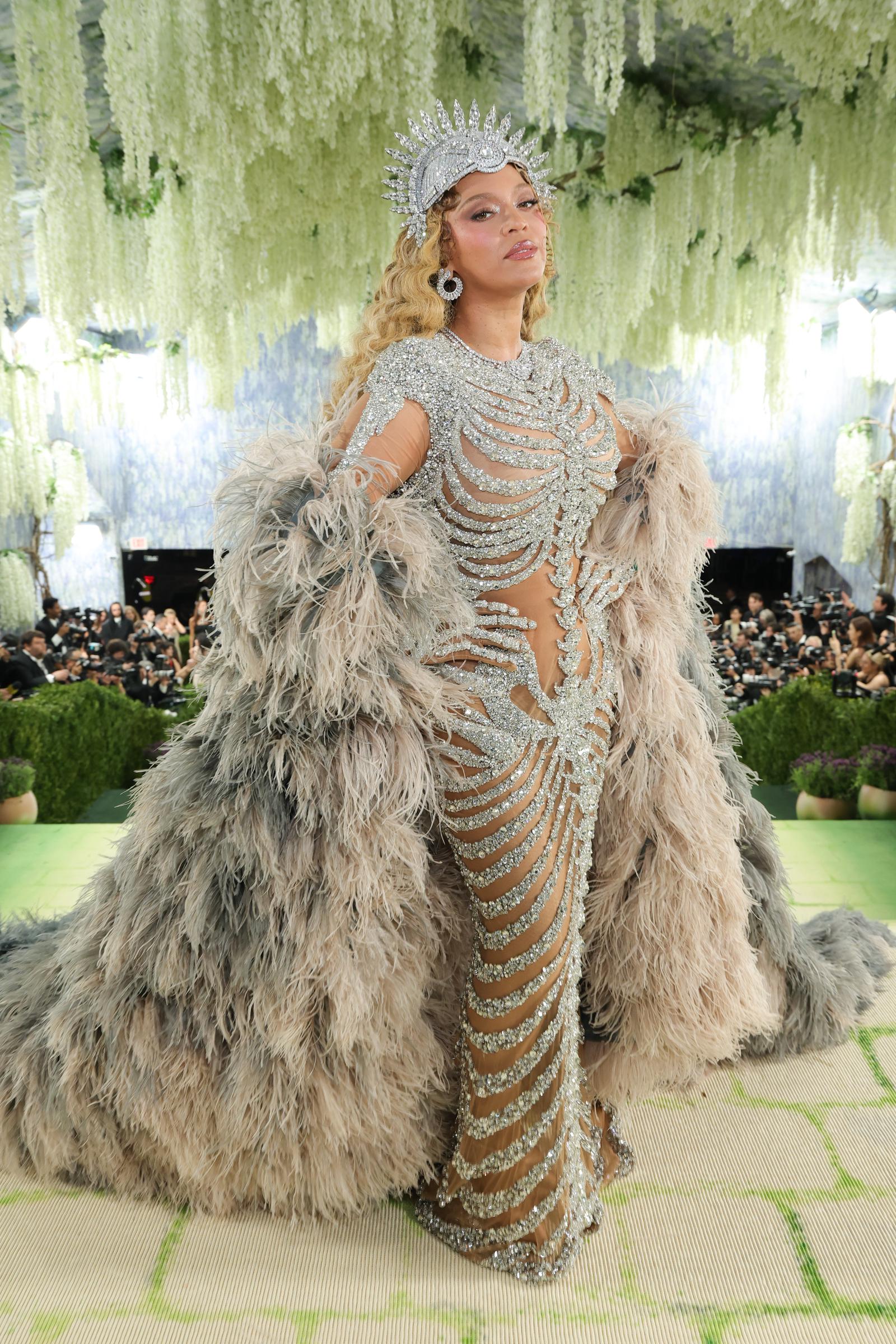Beyoncé poses in the full look, with her feathered coat framing the crystal gown | Source: Getty Images