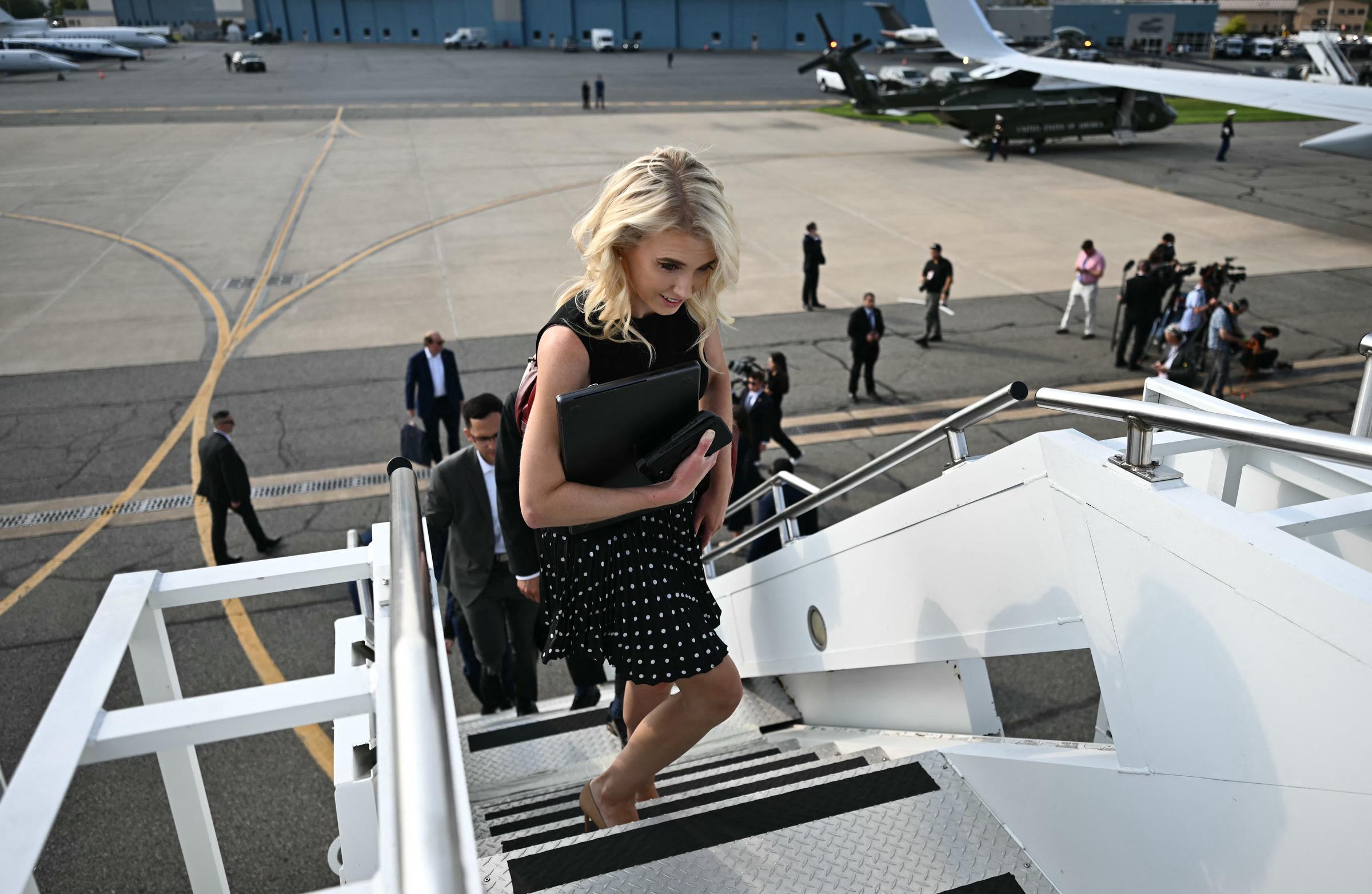 Natalie Harp boards a plane carrying the documents and devices that became part of her trademark role around Donald Trump. Behind that familiar routine, however, were letters to the president that reportedly left people in his inner circle increasingly uneasy. | Source: Getty Images
