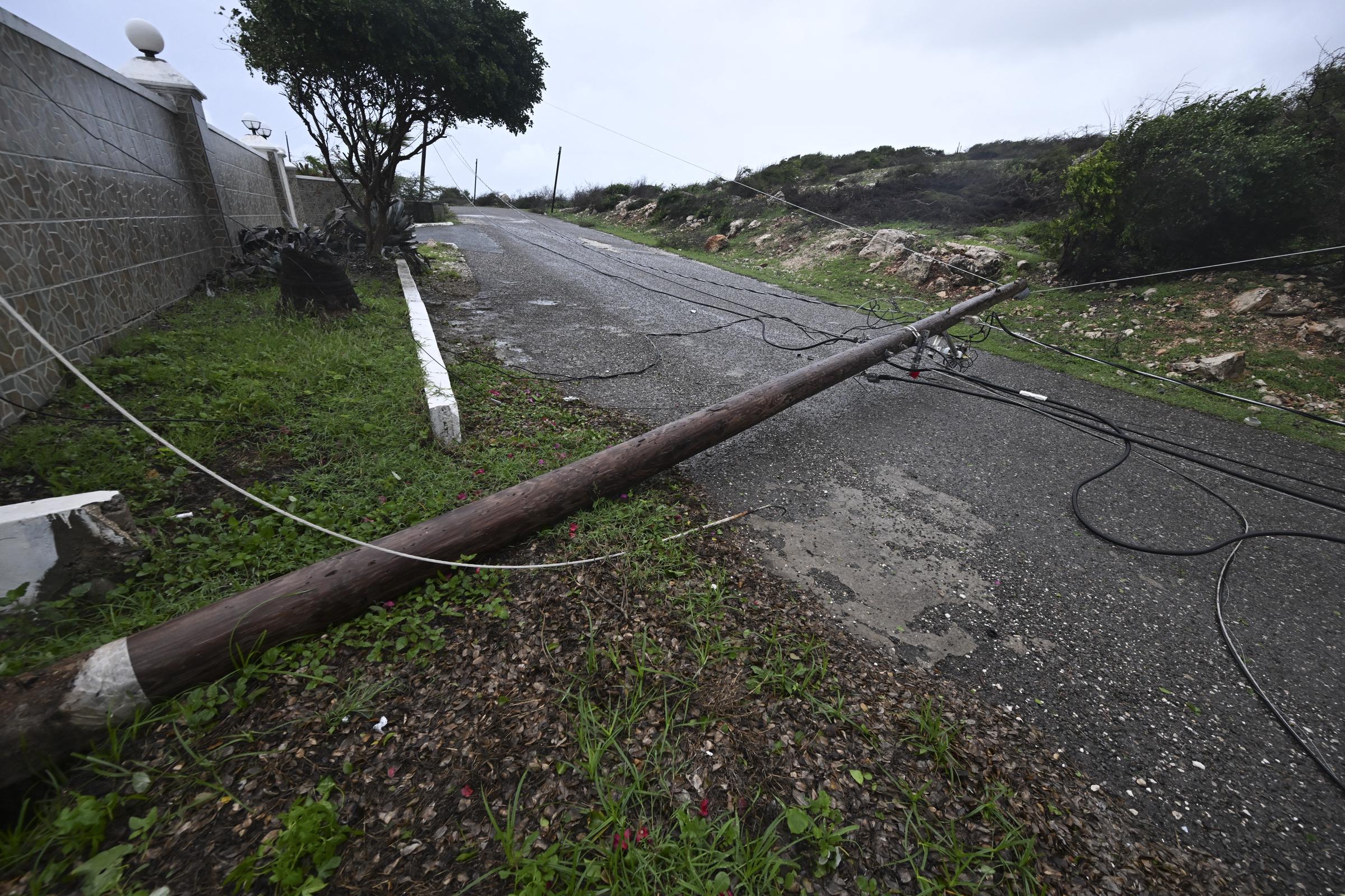 For illustration purposes: Destructive winds easily topple utility poles and power lines across roadways, creating hazardous conditions and cutting off electricity for local residents. | Source: Getty Image