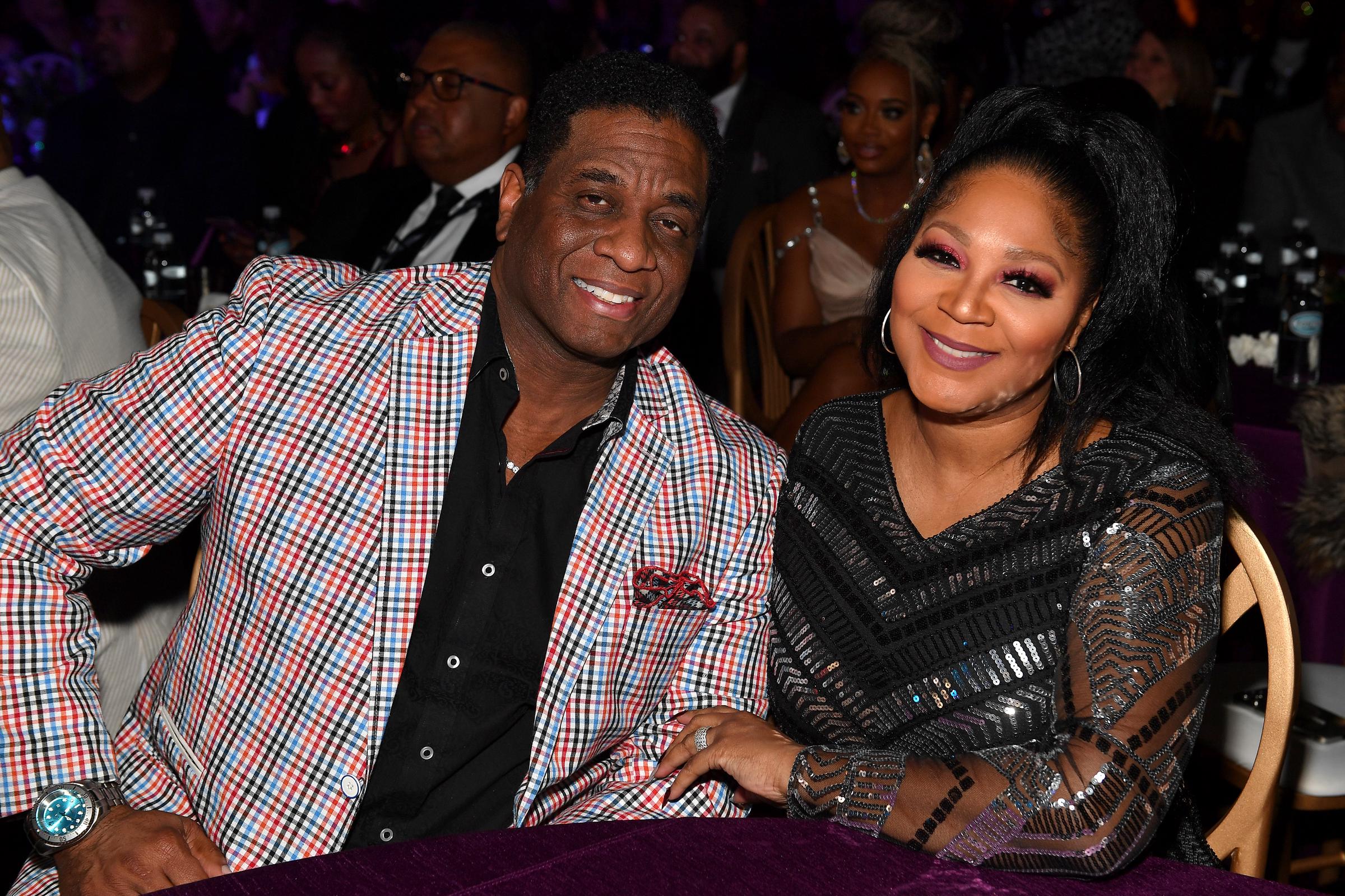 Von Scales and singer Trina Braxton smiled warmly while seated together at The 6th Annual URBAN ONE HONORS: Best In Black presented by TV One at the Coca-Cola Roxy on January 20, 2024, in Atlanta, Georgia. Scales stood out in an eye-catching red, black, and white plaid blazer paired with a black dress shirt, while Braxton dazzled beside him in a glittering, chevron-sequined black gown with sheer long sleeves, accessorized with hoop earrings and a high ponytail.