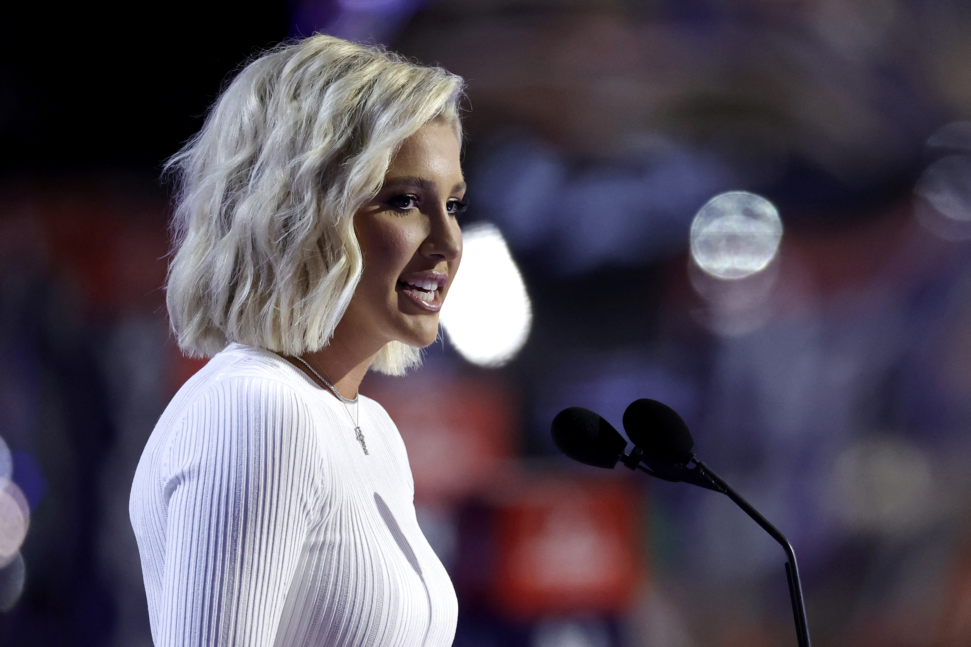 Savannah Chrisley speaks on stage during the second day of the Republican National Convention at the Fiserv Forum in Milwaukee, Wisconsin, on July 16, 2024, wearing a long-sleeved, ribbed white top paired with a delicate pendant necklace and styled with wavy, shoulder-length blonde hair. | Source: Getty Images
