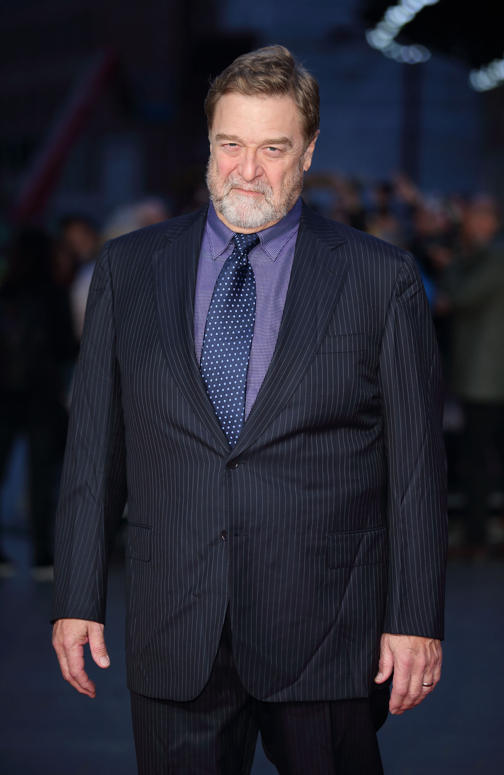 Dressed in a black suit with strips, worn over a shirt with patterns and a blue polka-dot tie, Goodman stepped onto the blue carpet at a screening of "Trumbo" during the BFI London Film Festival at Odeon Leicester Square. He completed his ensemble with a beard and a smirk on his face.