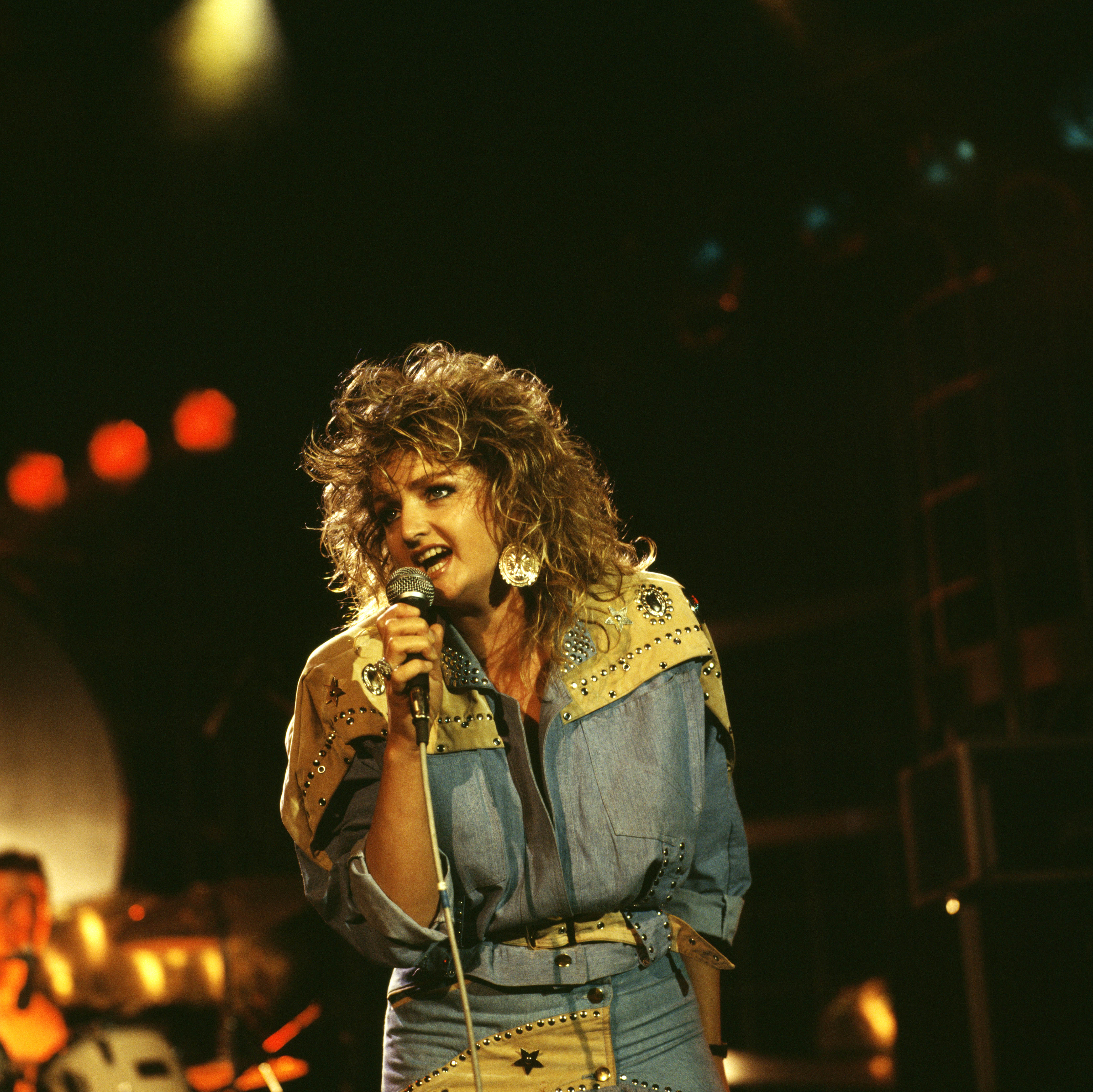 Bonnie Tyler delivers a powerful performance at the height of her rise to international stardom, gripping the microphone under the stage lights as her unmistakable voice and commanding presence captivated audiences around the world. | Source: Getty Images