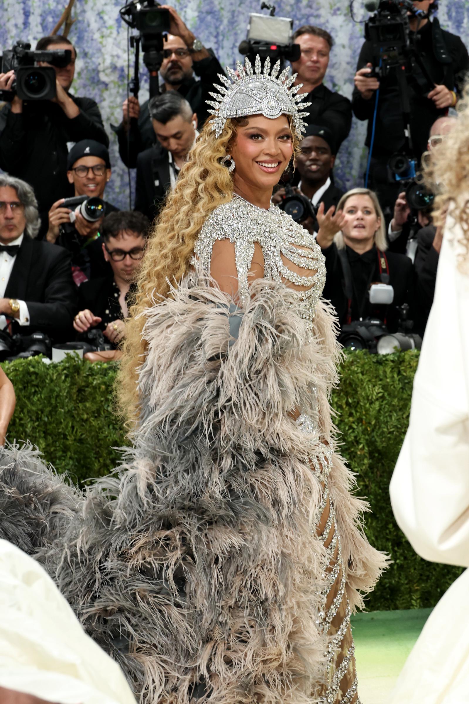 Beyoncé turns to the side, showing her long blonde waves and layered feathers | Source: Getty Images