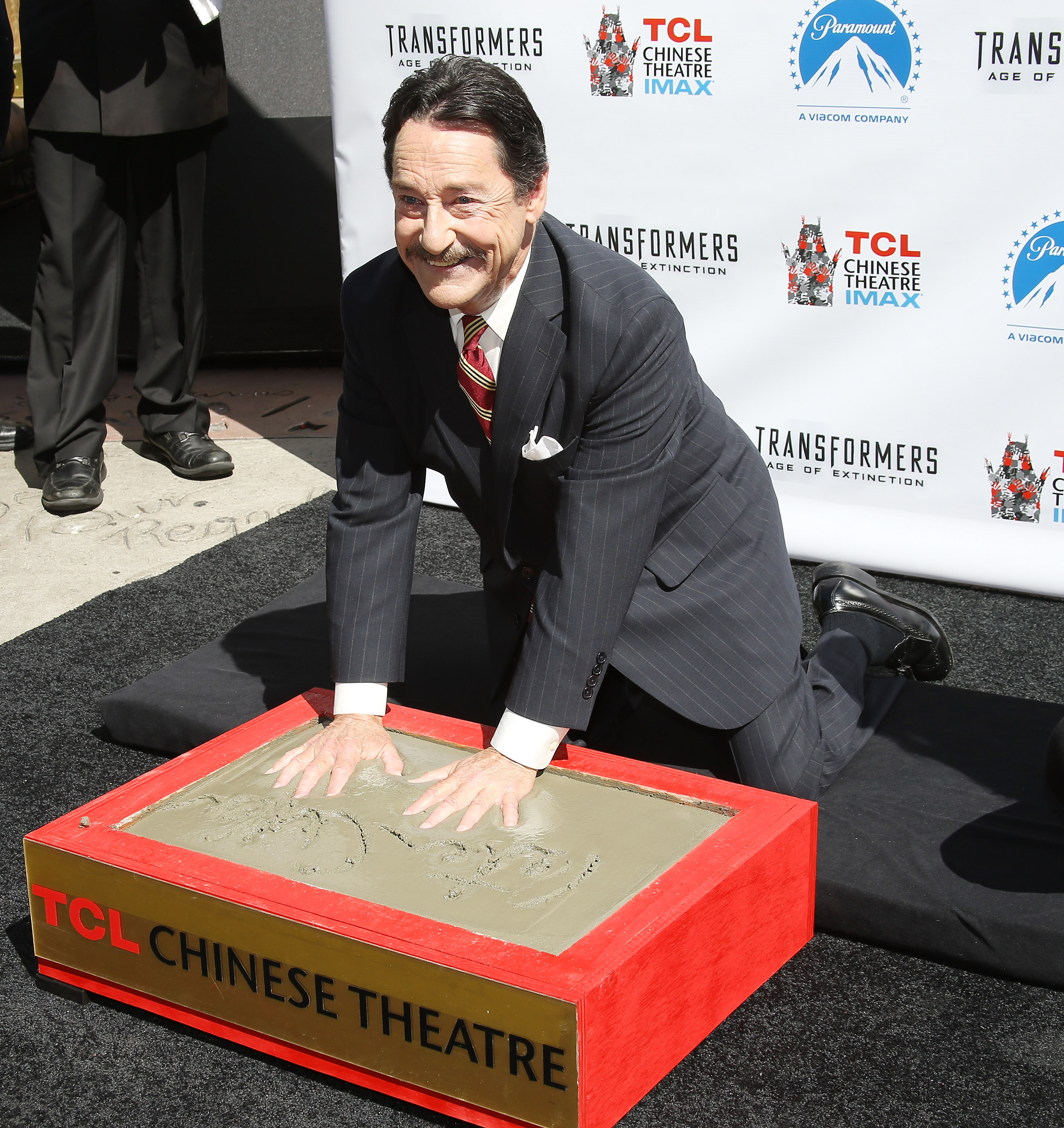 Peter Cullen leaves his handprints and footprints in cement at the TCL Chinese Theatre in Hollywood in 2014, marking a rare honor that recognized the man behind Optimus Prime rather than the character alone. The ceremony came as Cullen’s voice had become inseparable from the heroic Autobot leader. | Source: Getty Images