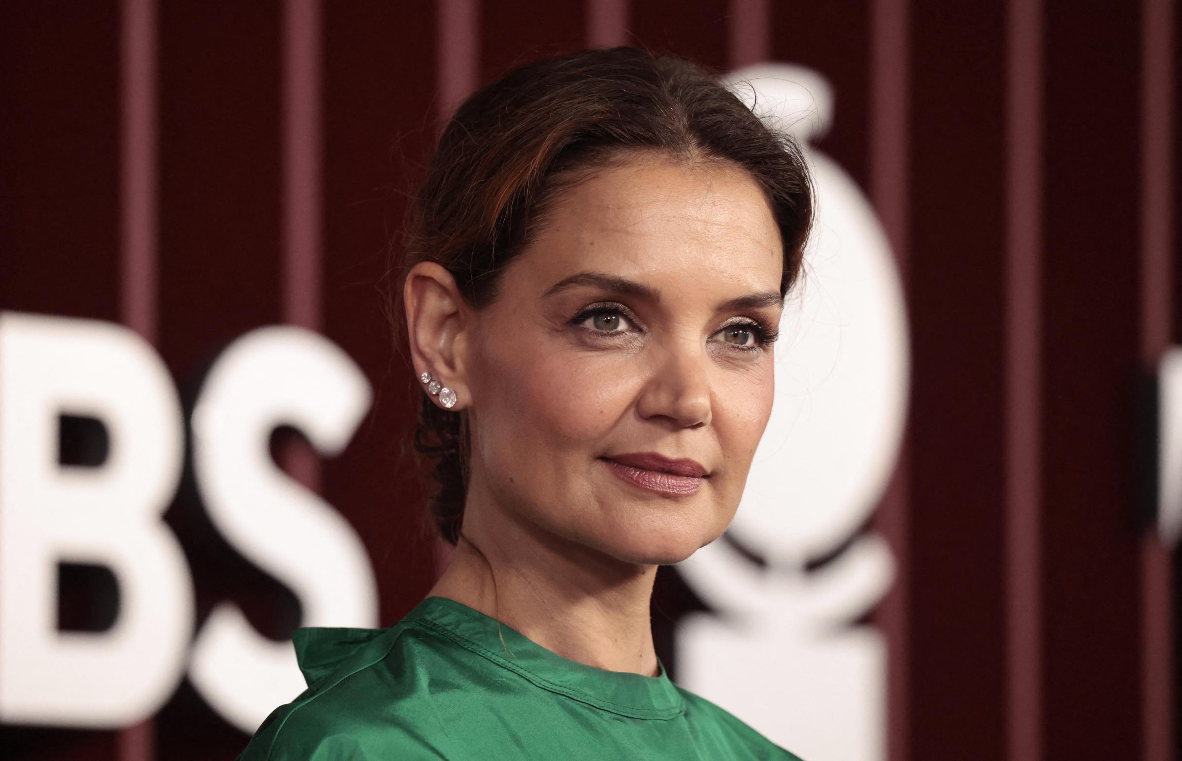With her hair styled in a sleek updo and a fresh, glowing makeup look, Katie Holmes brings understated elegance to the red carpet at the 2025 Tony Awards in New York, pairing a bold green top with sparkling jewelry.
