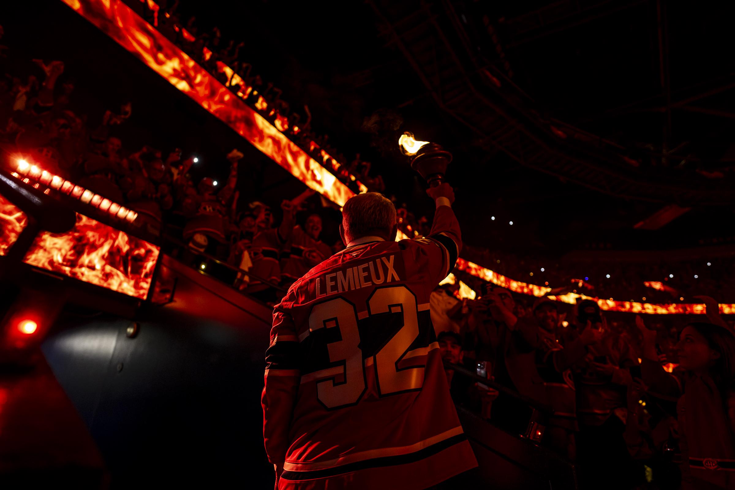 Claude Lemieux carries the torch in the opening ceremony of Game Three of the Eastern Conference Final of the Stanley Cup Playoffs between the Montreal Canadiens and the Carolina Hurricanes at the Bell Centre in Montreal, Quebec, Canada on May 25, 2026. | Source: Getty Images