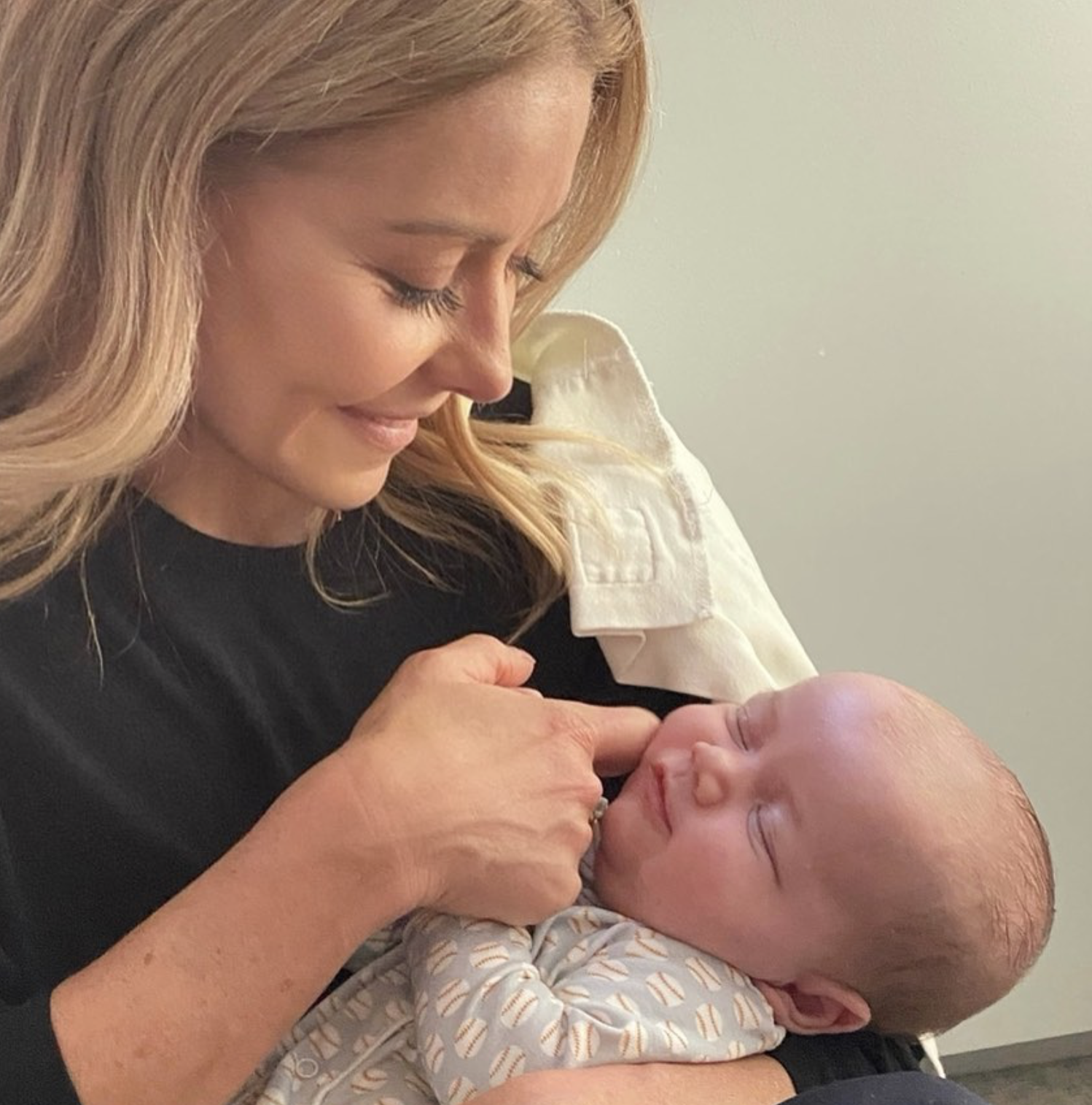 Kelly Ripa shares a tender moment with a newborn baby, smiling lovingly as she gently touches the little one's cheek. | Source: Instagram/@kellyripa