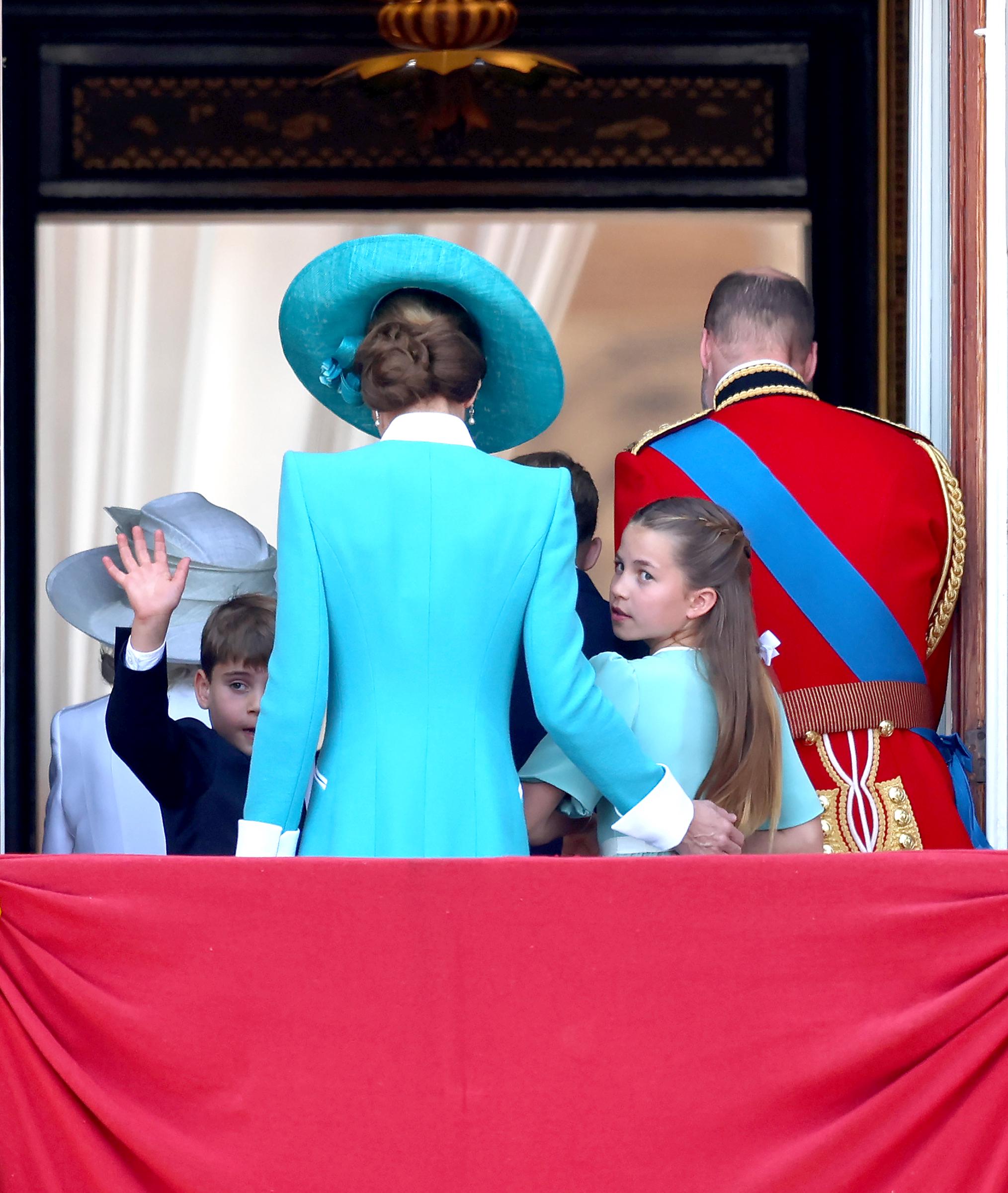 Princess Charlotte looks back at the crowd from the balcony as she heads inside with Princess Catherine, Prince William, Princes George and Louis, and other royals during the 2025 Trooping The Colour.