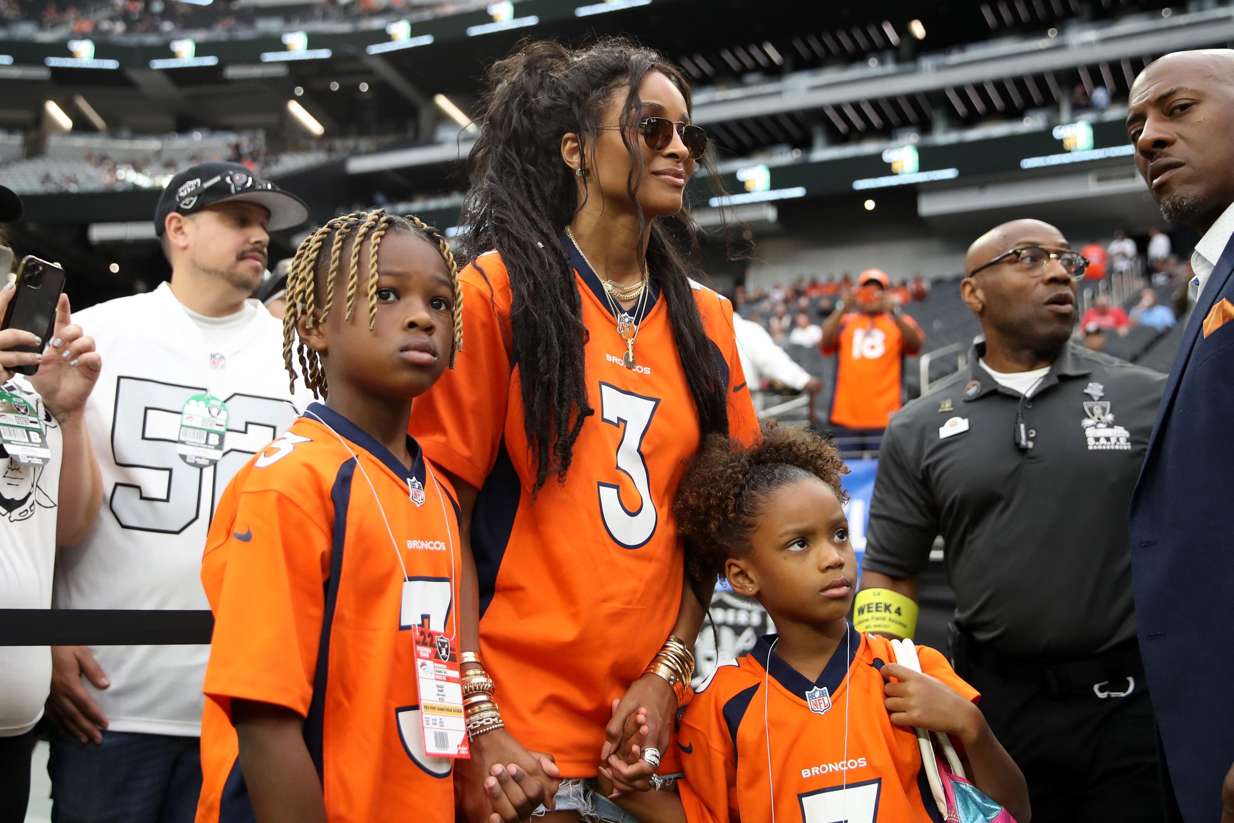 Future Zahir Wilburn, 8, Ciara Wilson, 36, and Sienna Princess Wilson, 5, look on from the field before the game between the Denver Broncos and Las Vegas Raiders at Allegiant Stadium on October 2, 2022, in Las Vegas, Nevada.