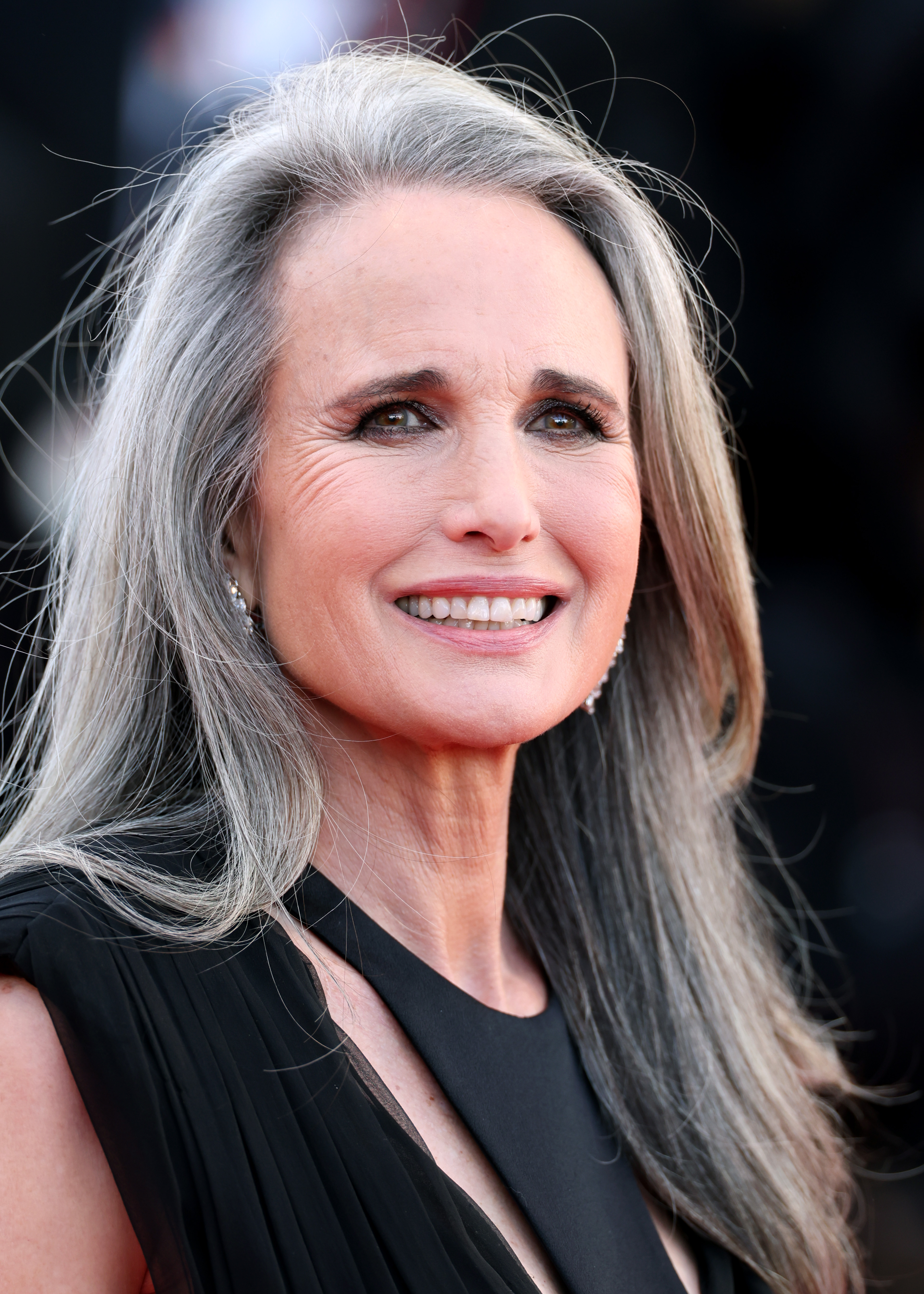 Andie MacDowell's striking salt-and-pepper hair has become one of her most recognizable features, and she maintains its silver tone with purple conditioners rather than returning to regular hair dye. | Source: Getty Images