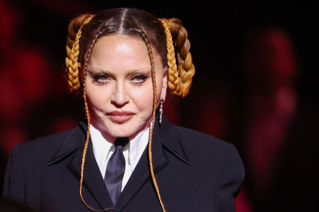 Madonna appears at the 2023 Grammy Awards in a black tailored look with her braids arranged into sculptural loops. Her appearance soon drew widespread attention. | Source: Getty Images