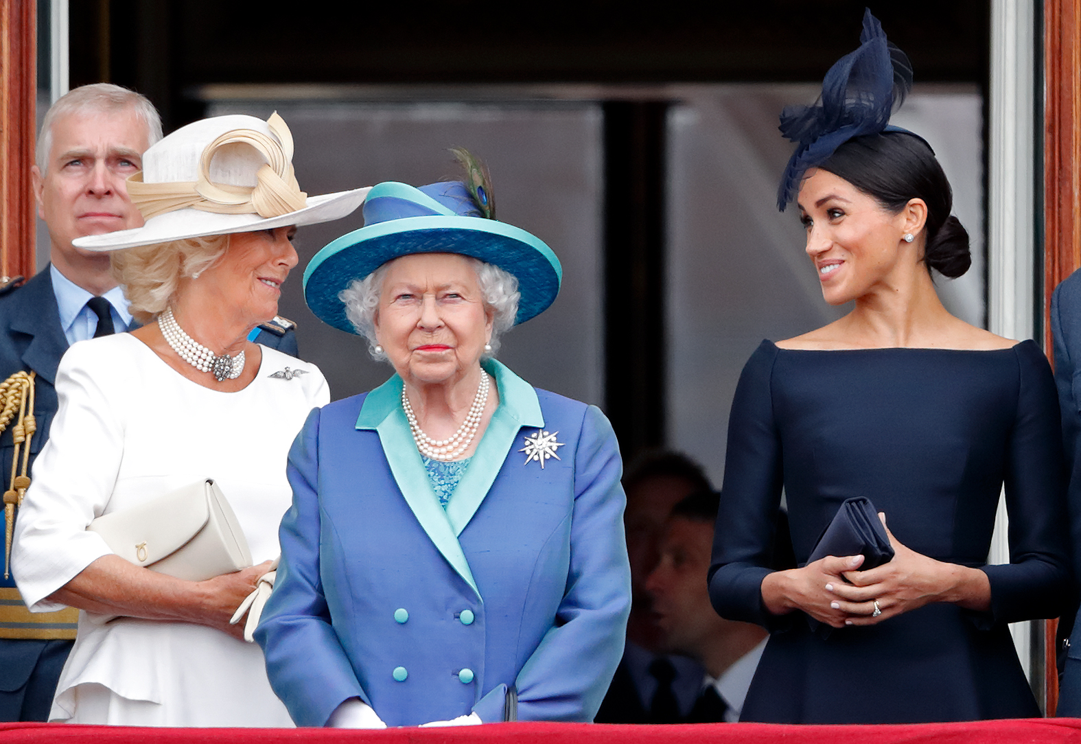 Queen Camilla, Queen Elizabeth II and Meghan Markle watch a flypast to mark the centenary of the Royal Air Force from the balcony of Buckingham Palace on July 10, 2018, in London, England | Source: Getty Images