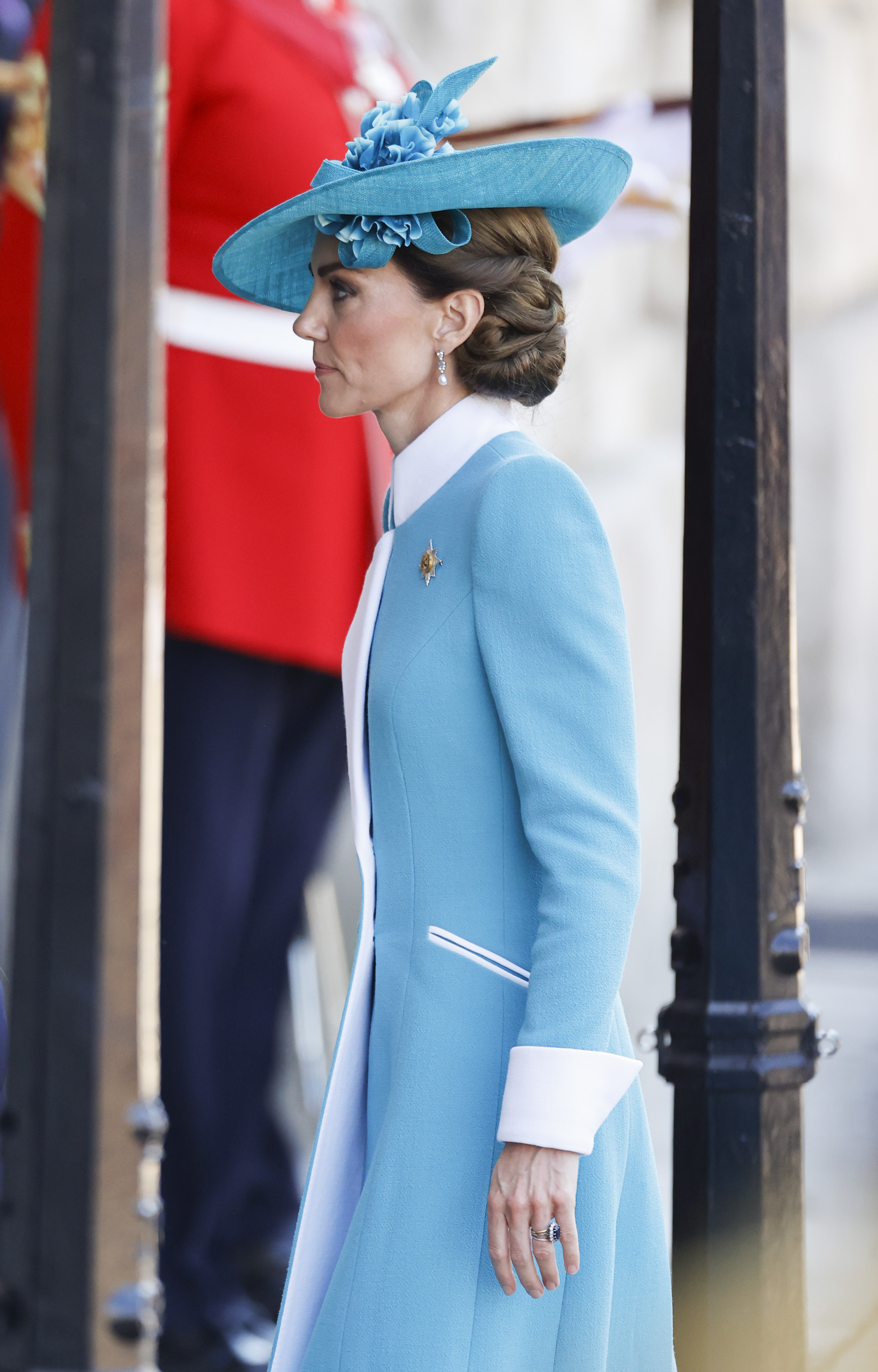 Seen in full from a graceful side angle, Princess Catherine showcases her elegant 2025 Trooping the Colour attire—a structured teal coat with crisp white detailing at the collar and cuffs.