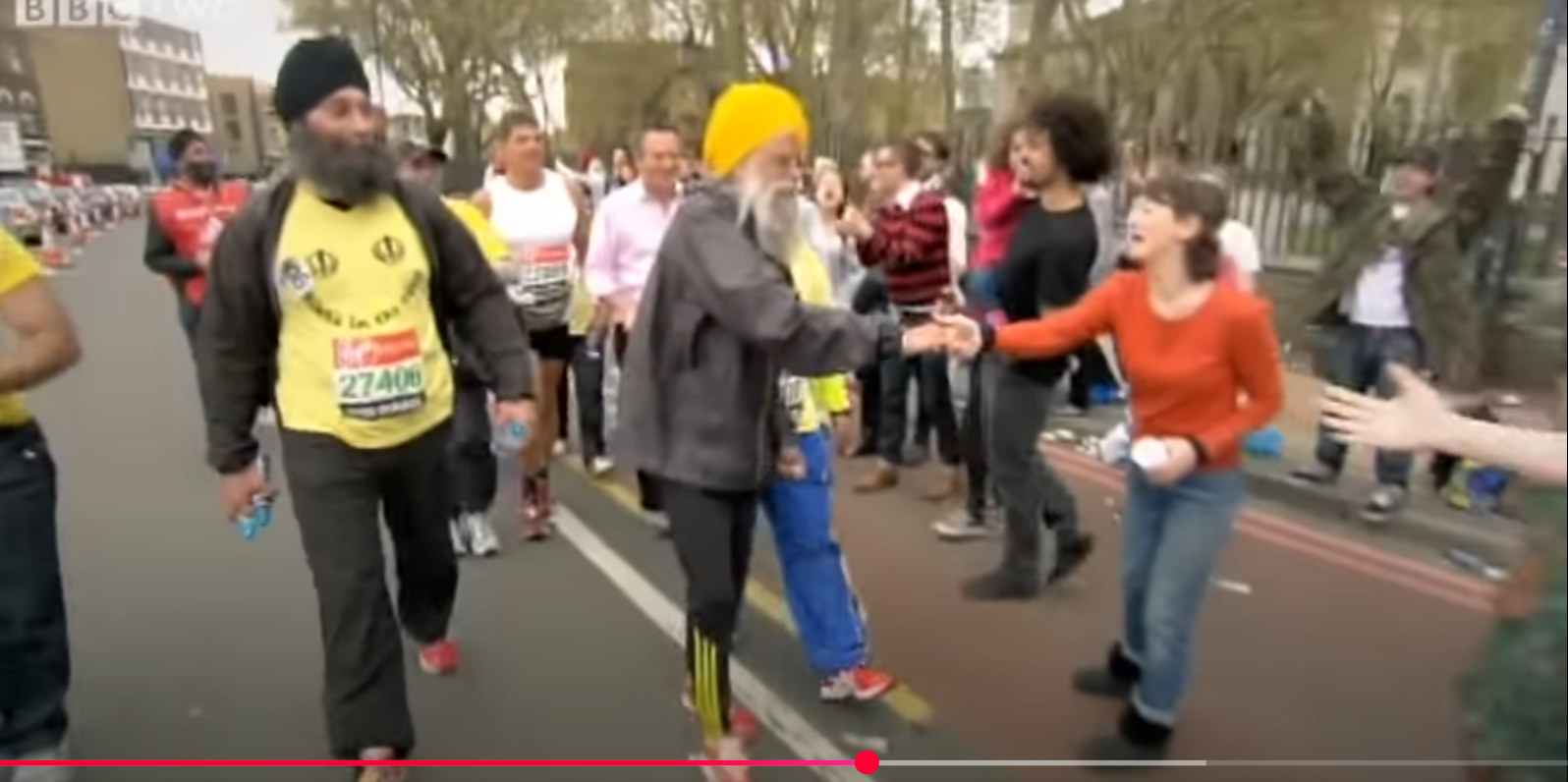 Fauja Singh shakes hands with onlookers during the London Marathon. From a video dated August 6, 2012. | Source: YouTube/BBC