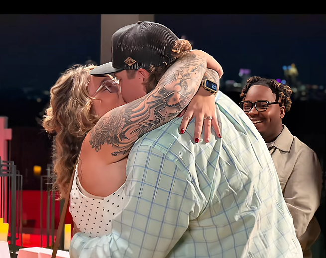 Pumpkin and Darrin share a kiss after he proposes, with Pumpkin wrapping her tattooed arms around her fiancé. Dralin smiles in the background as the couple celebrates the beginning of their engagement. | Source: TikTok/Mama P
