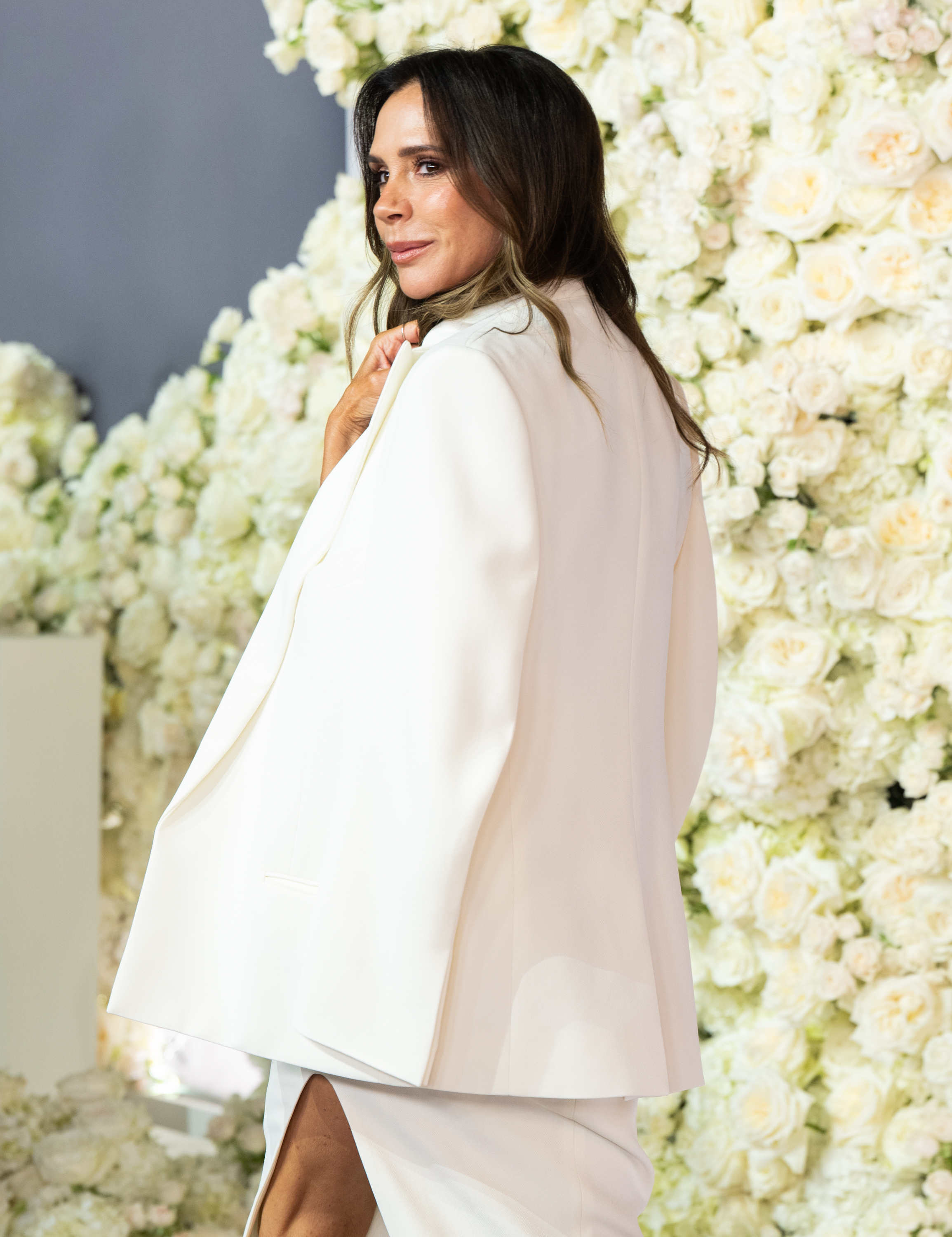 Victoria has also been photographed from behind at major public appearances, giving a different view of her polished style. At the London premiere of "Victoria Beckham" in October 2025, she posed in a white tailored look, months before her Portofino outfit became a subject of online discussion. | Source: Getty Images