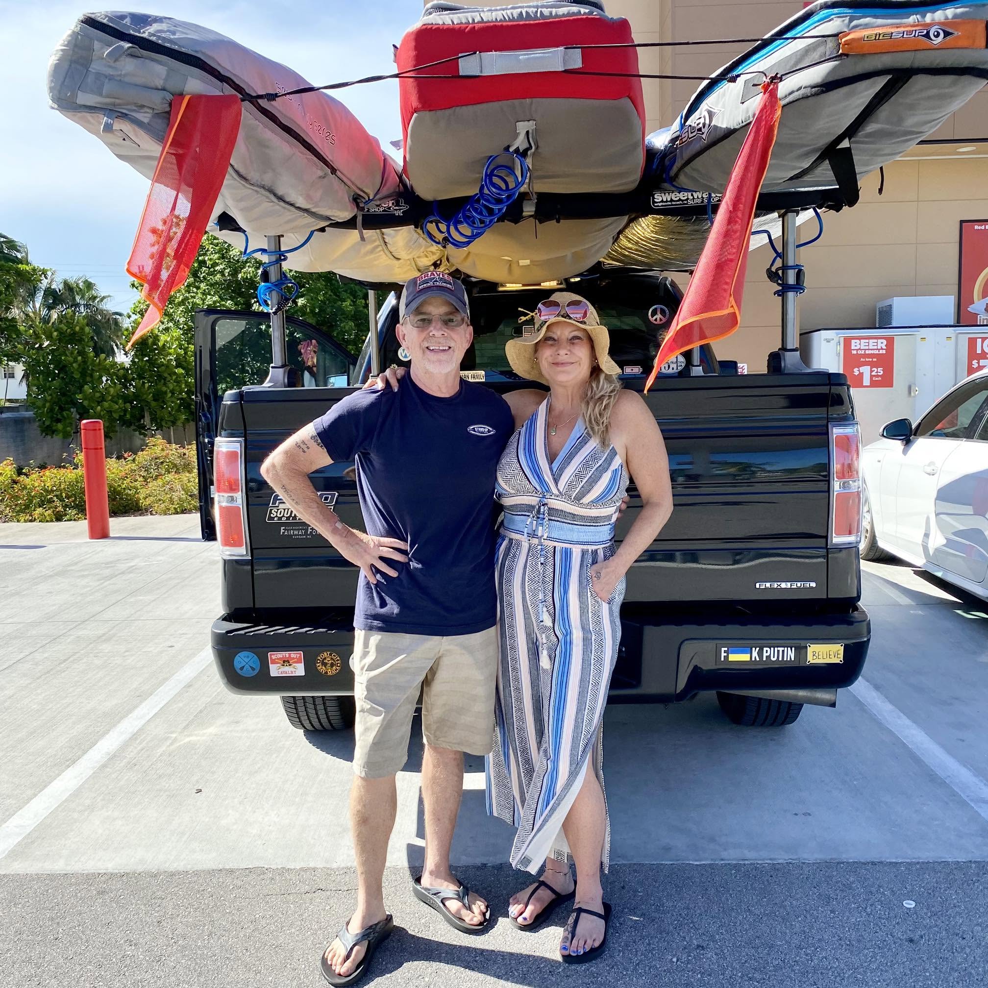 Stephen and Tracey Willetts pose for a photo in front of their truck carrying paddleboards posted on July 17, 2024. | Source: Facebook/Tracey Parker Willetts