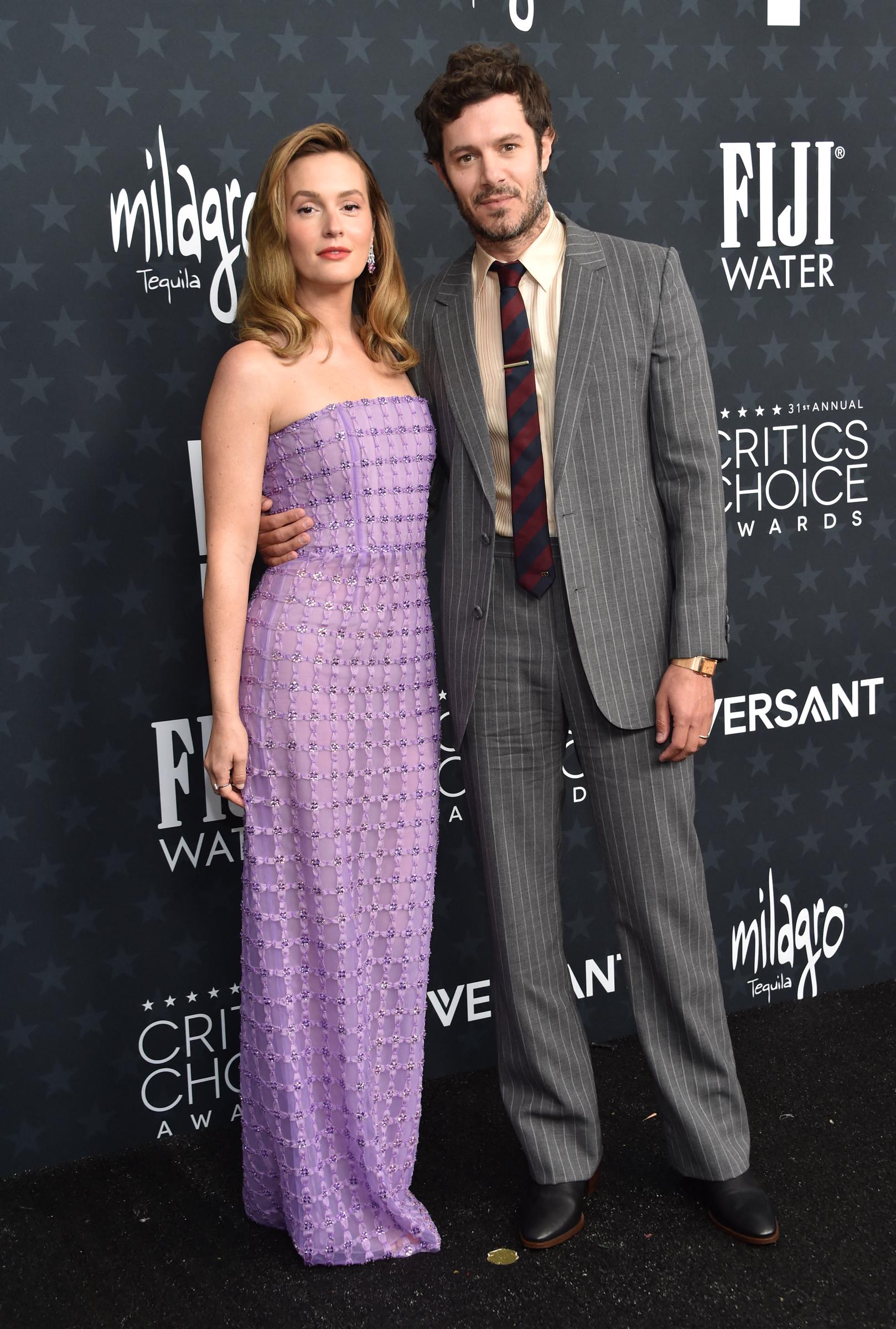 Leighton Meester and Adam Brody make a stylish couple appearance, with her in soft lavender and him in a striped gray suit | Source: Getty Images