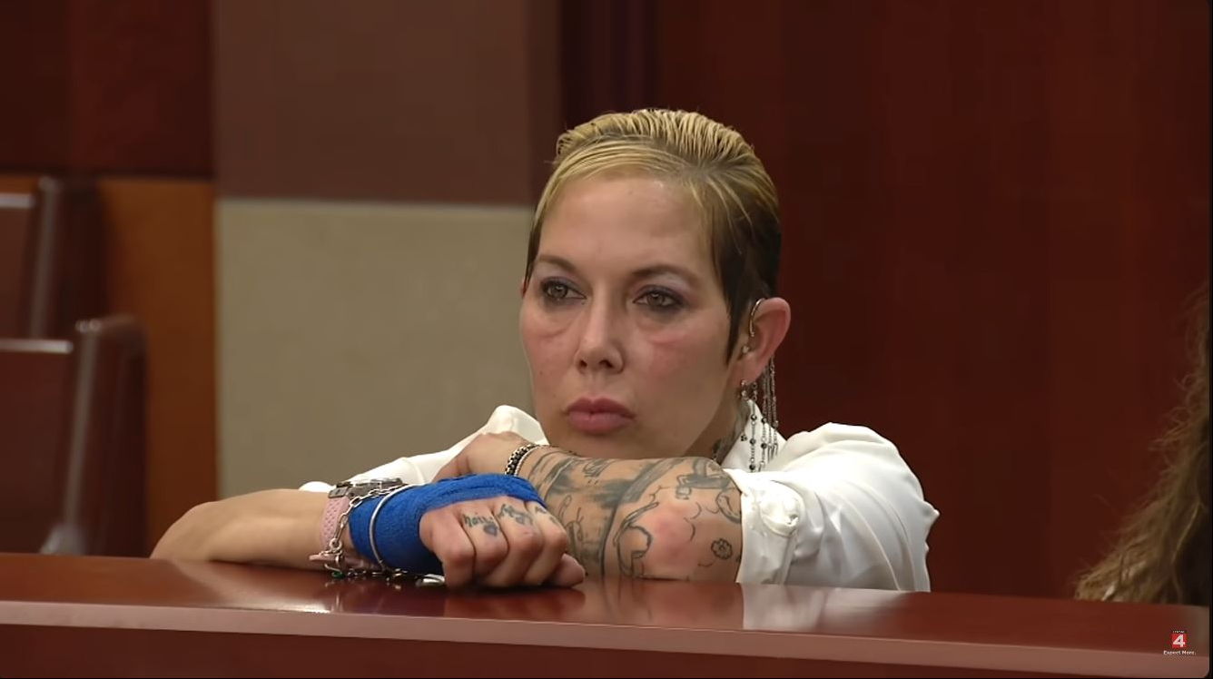 With her tattooed arms resting across the courtroom barrier, Scott appeared to listen to the proceedings while wearing bracelets and a blue support around one hand. Eminem's former wife, with whom he shares a daughter, Hailie Jade Scott, kept her gaze forward as her legal troubles brought her back into public view. | Source: YouTube/Click On Detroit | Local 4 | WDIV