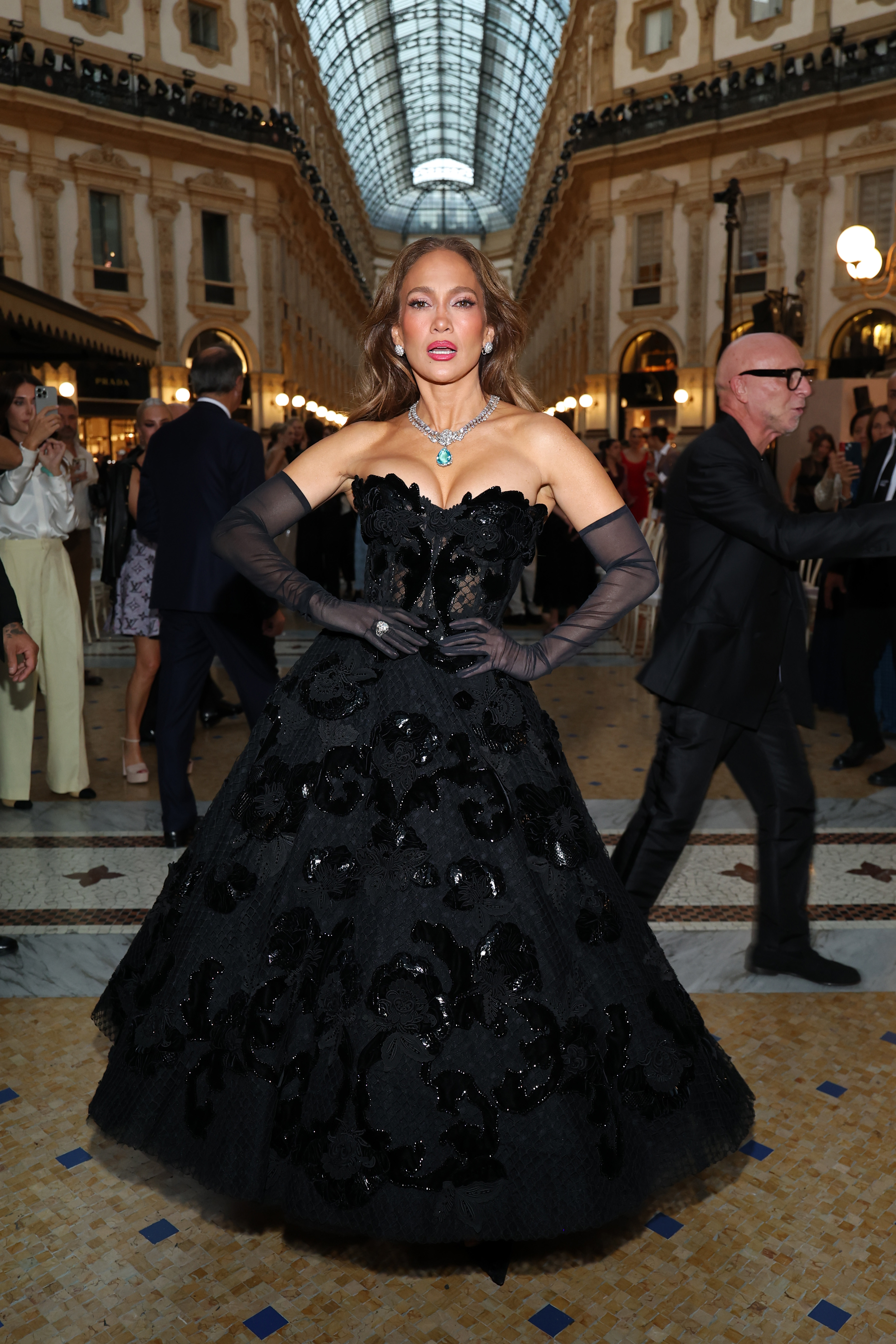 Lopez poses with her hands at her waist, showing off the full shape and floral detailing of her black ball gown. | Source: Getty Images