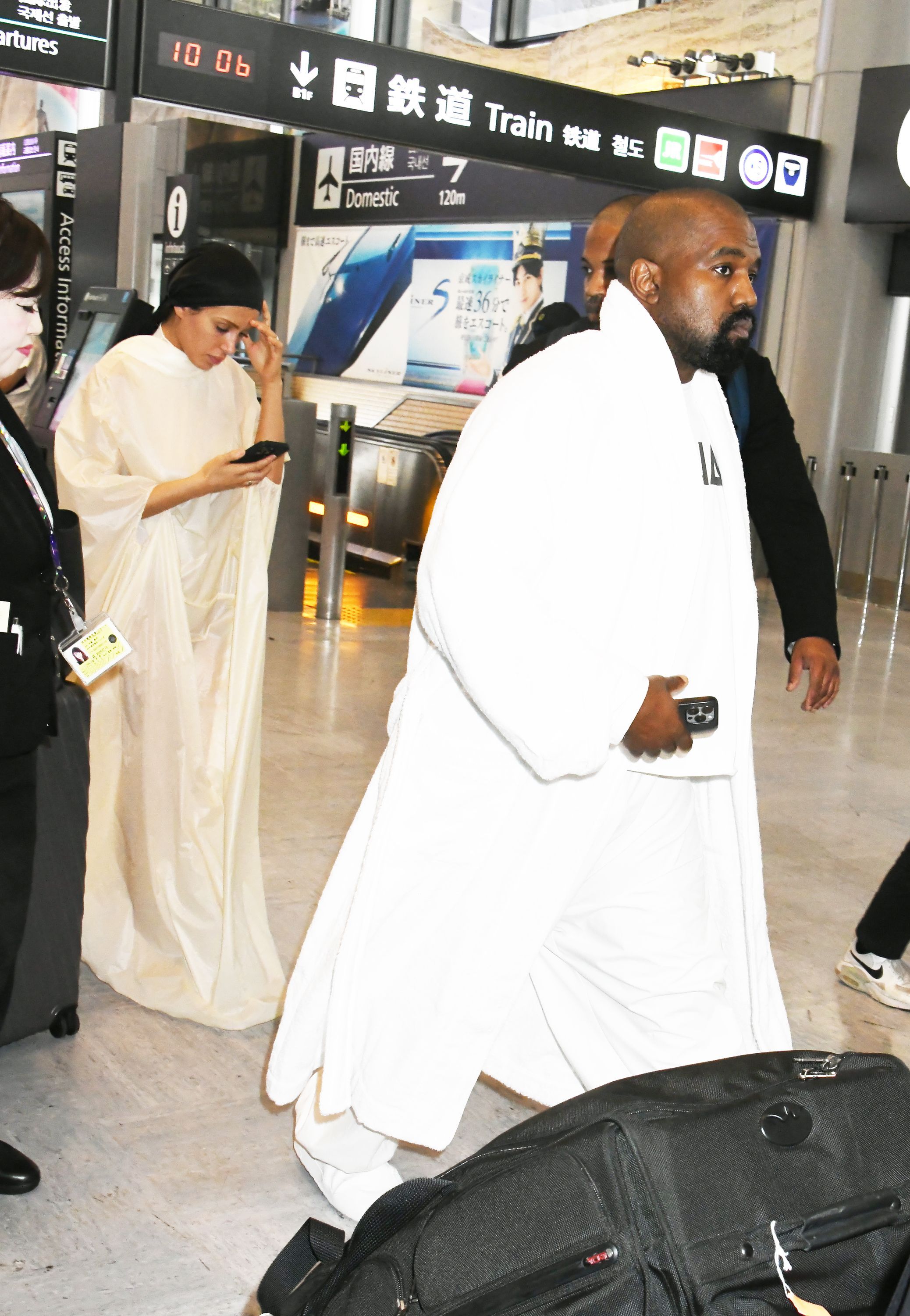 Kanye West walks ahead while Bianca Censori checks her phone after arriving at Narita International Airport in Tokyo on June 9, 2024 | Source: Getty Images