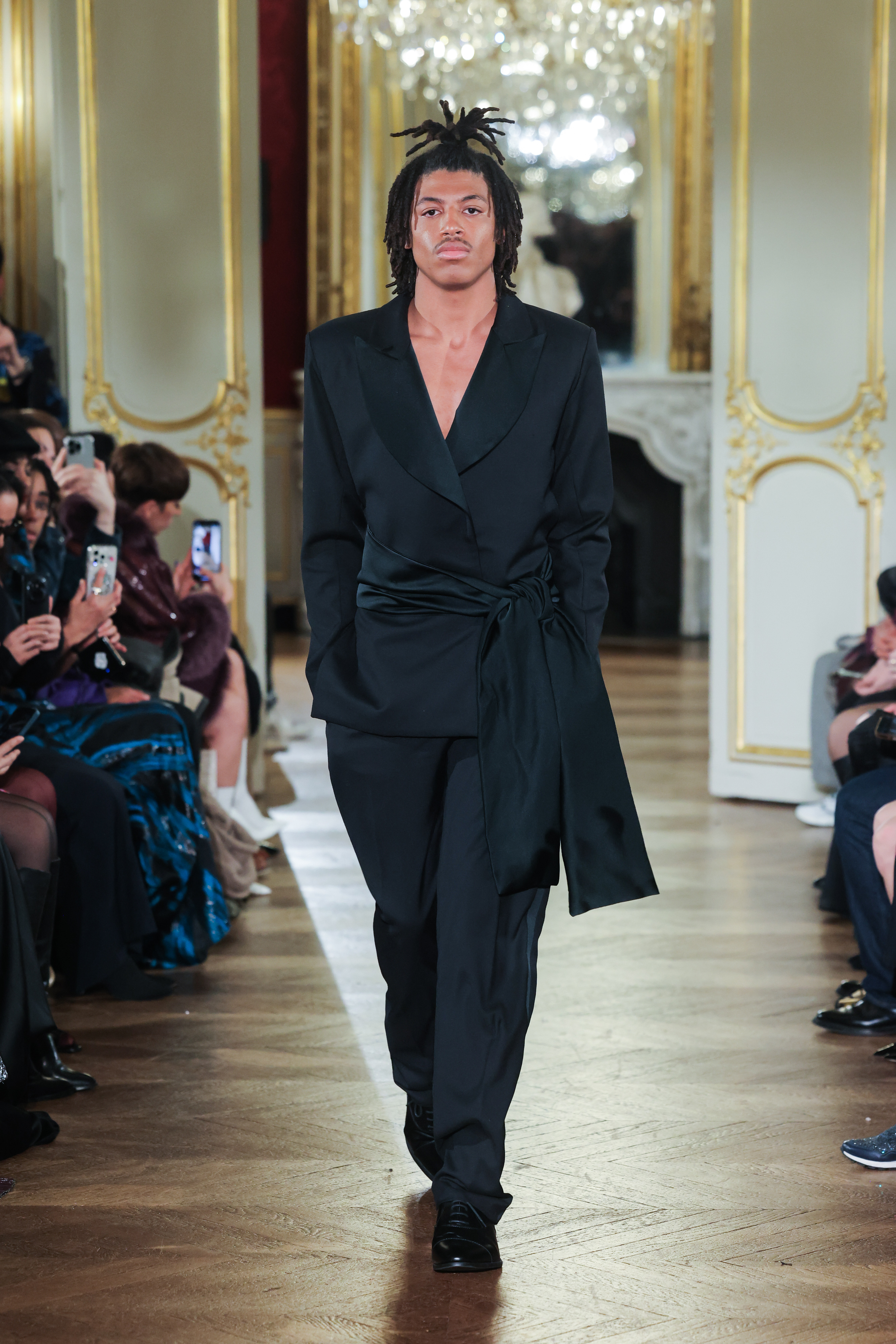 Henry Samuel walks the runway during Paris Fashion Week, marking his runway debut in a black tailored ensemble. | Source: Getty Images