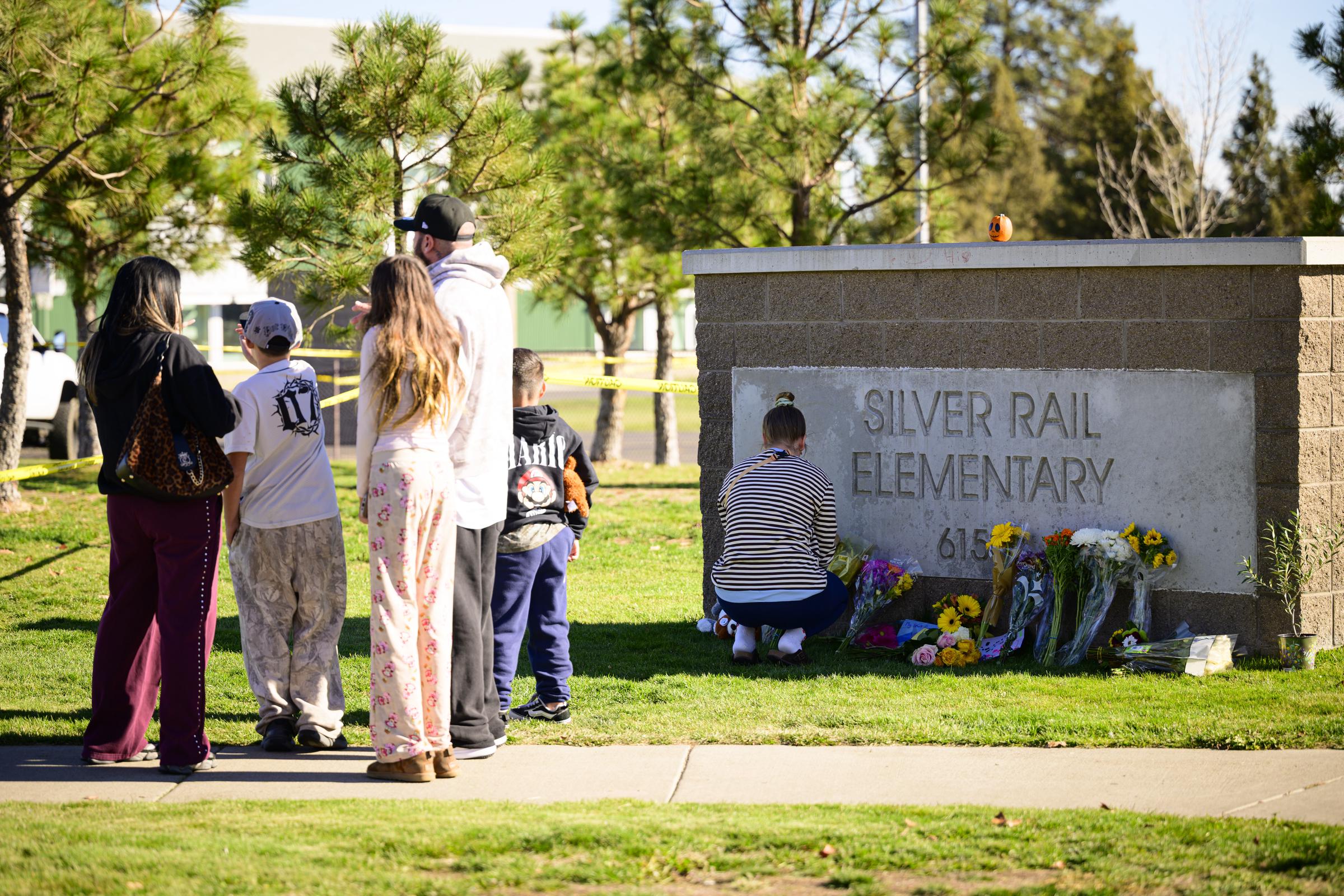 Flowers were left beneath the Silver Rail Elementary School sign as the community mourned the victims, while police tape remained around the grounds during the investigation. | Source: Getty Images.