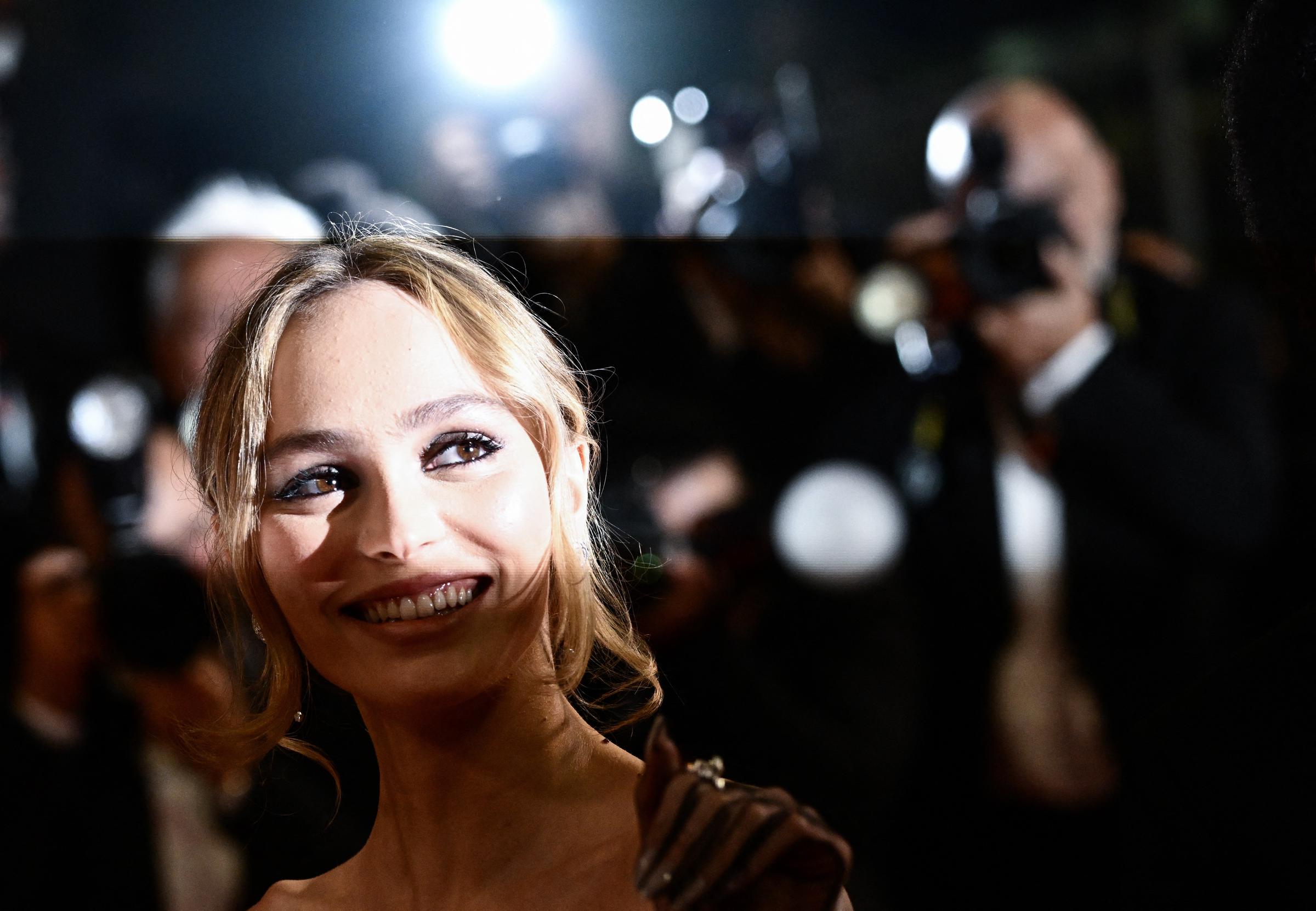 Lily-Rose Depp smiles for photographers at the Cannes Film Festival on May 22, 2023, during a screening of "The Idol." The actress has spoken about wanting her performances to define her public image rather than her family background. | Source: Getty Images