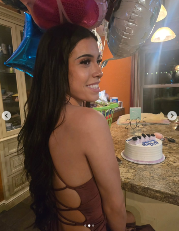 Marissa DiNapoli poses beside a cake with "2025" candles during a celebration, posted on July 1, 2025 | Source: Instagram/moniice__