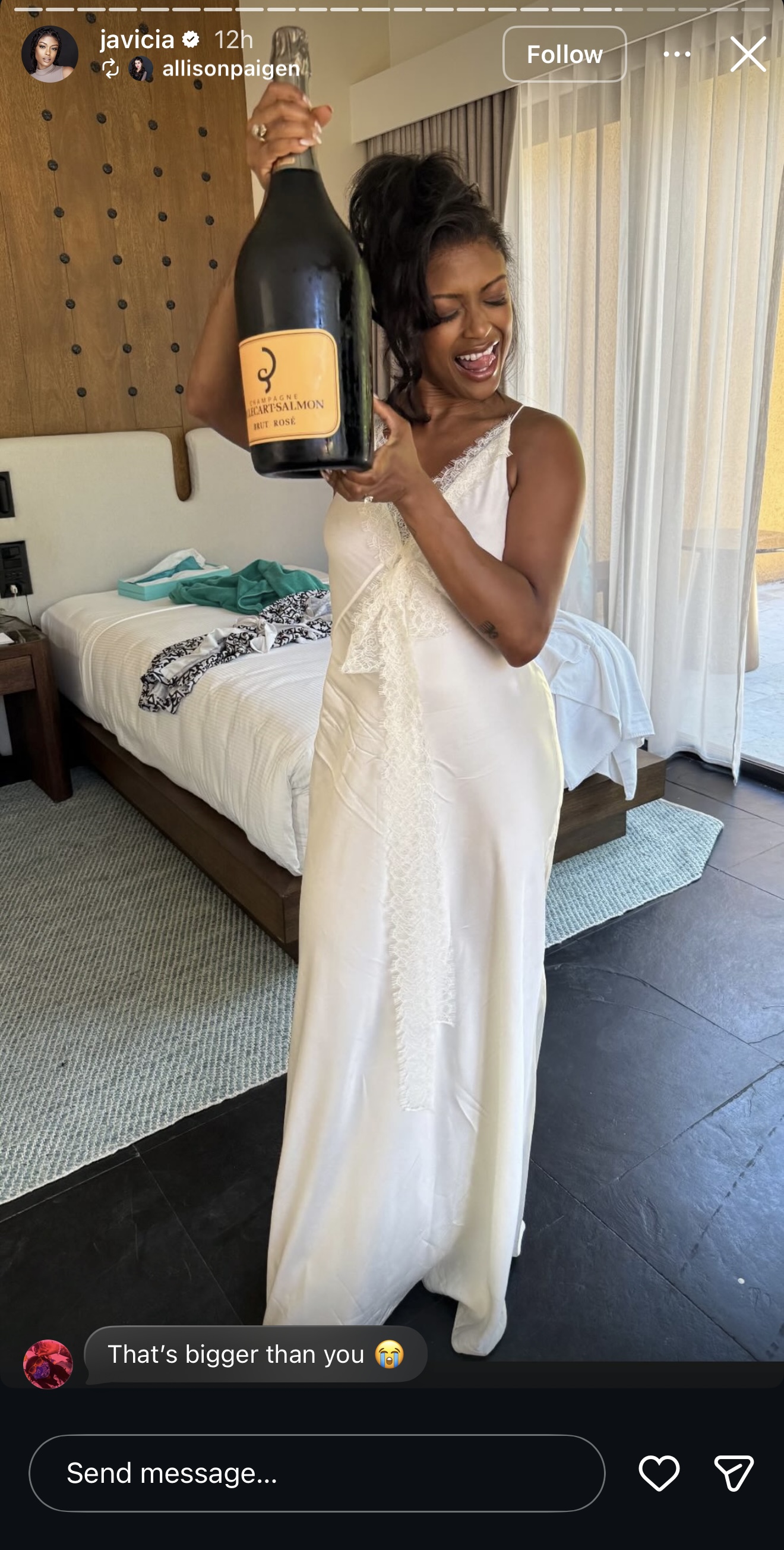 Javicia Leslie holds an oversized champagne bottle in a hotel room before her wedding ceremony. | Source: Instagram/javicia