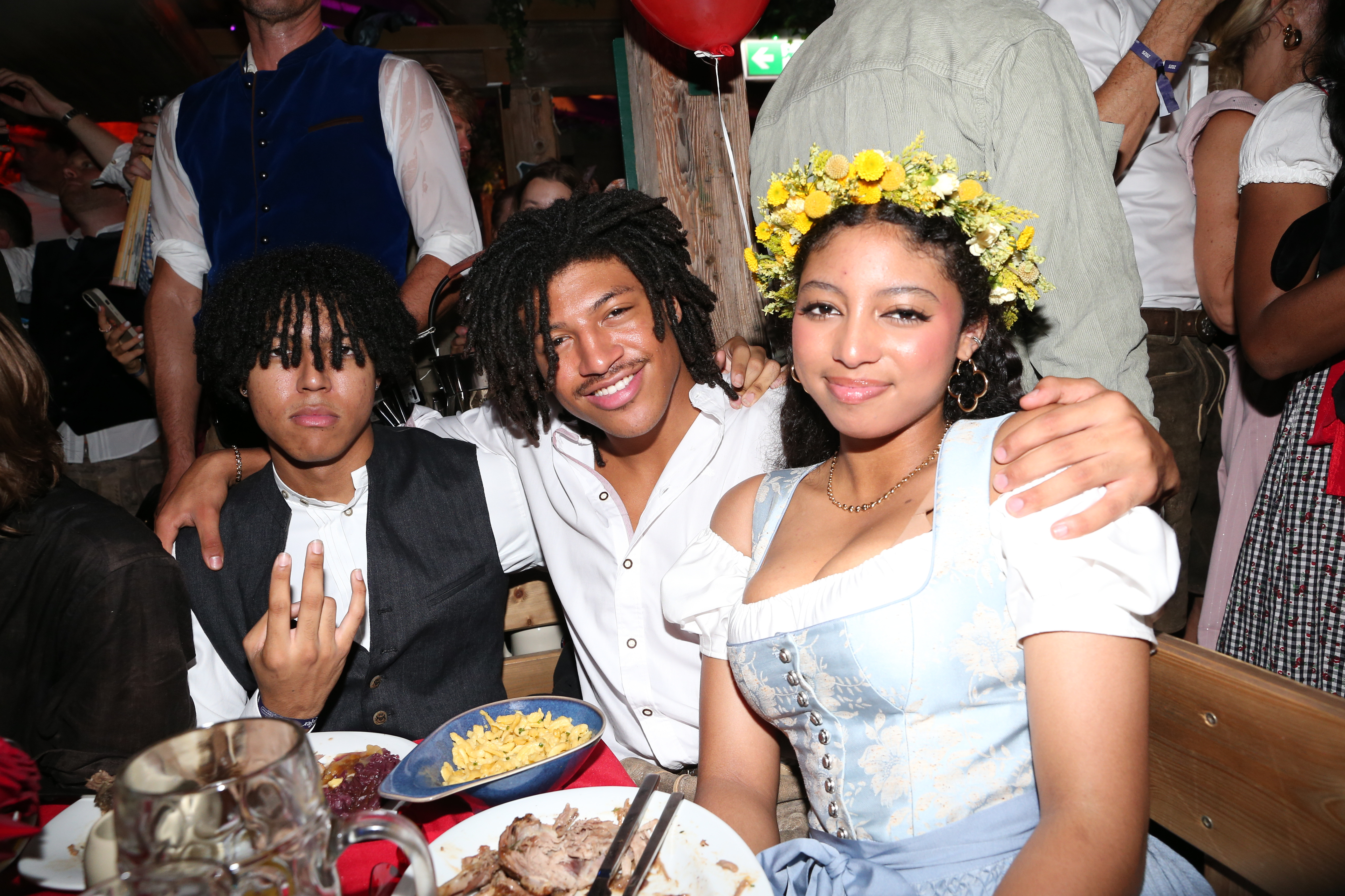 Johan, Henry, and Lou Samuel sit side by side at Oktoberfest in Munich, Germany, on September 20, 2025 | Source: Getty Images