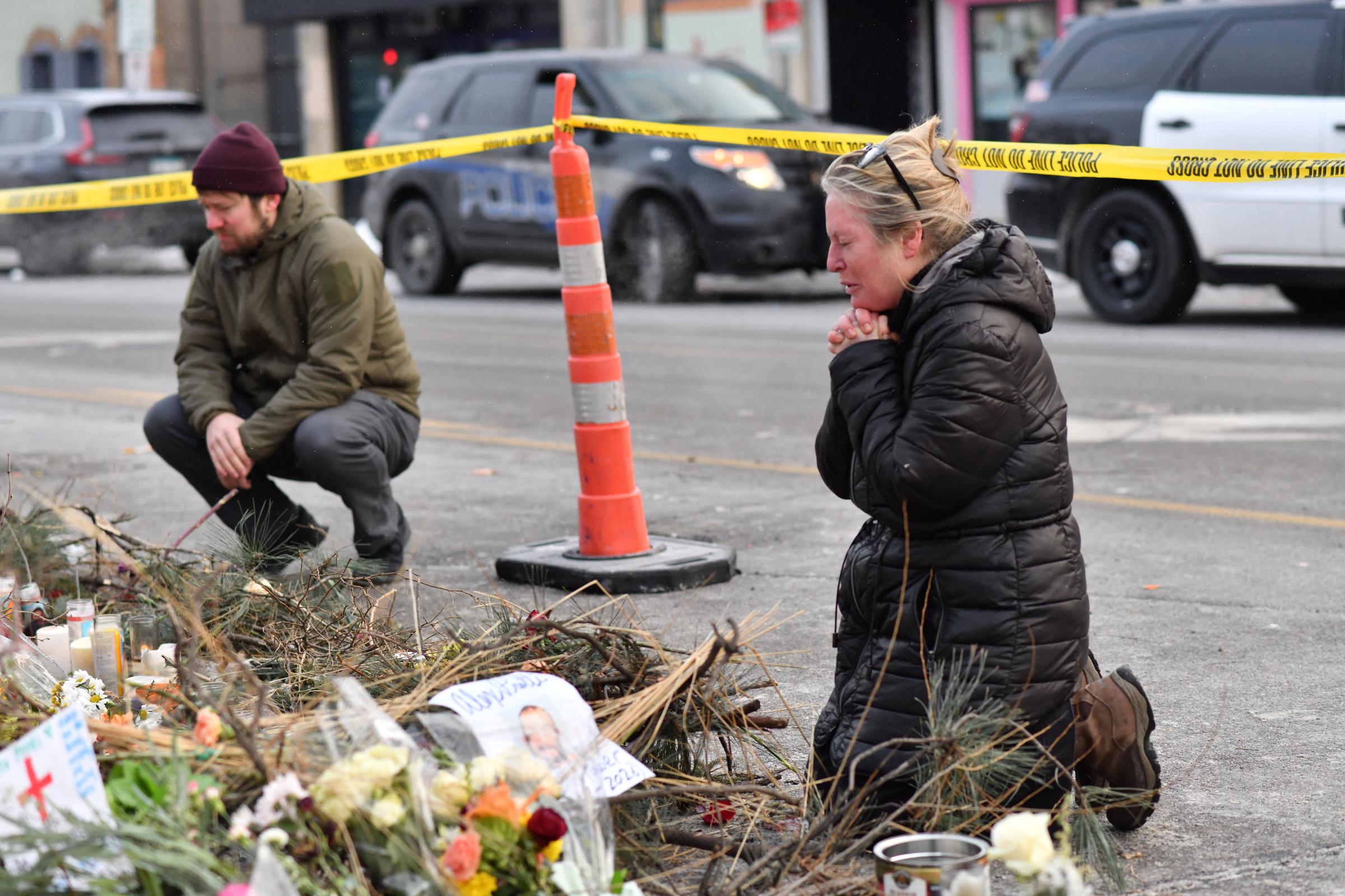 Mourners kneel at a makeshift memorial in the area where Alex Pretti was shot a day earlier by federal immigration agents on January 25, 2026, in Minneapolis, Minnesota | Source: Getty Images